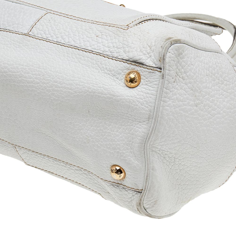Bewahren Sie Ihre täglichen Habseligkeiten sicher und elegant in dieser schicken Schultertasche von Dolce & Gabbana auf. Sie ist aus weißem Leder gefertigt und mit einer goldfarbenen Logoplakette auf der Vorderseite versehen. Sie ist mit zwei