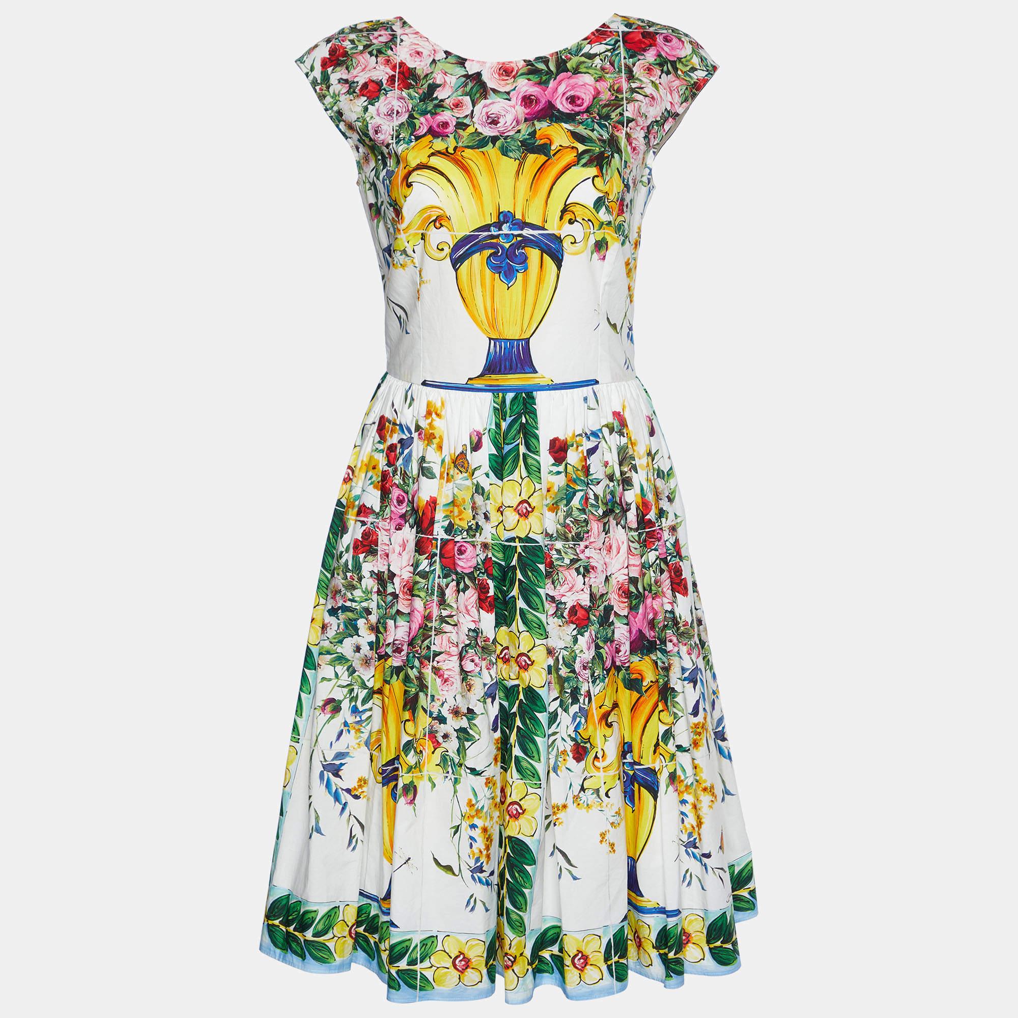 The Dolce & Gabbana dress is a stunning fashion piece. Crafted from high-quality cotton, it features a white background adorned with vibrant Majolica-style rose prints. This midi-length dress offers a flattering silhouette and exudes Italian luxury,