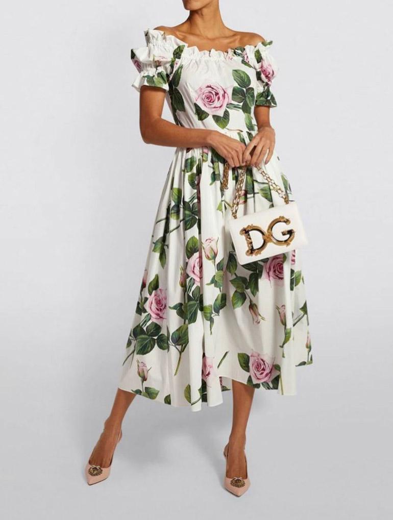 DOLCE & GABBANA TROPICAL ROSE-PRINT OFF-THE-SHOULDER COTTON-POPLIN DRESS IN WHITE
With its painterly blooms, Dolce & Gabbana’s white midi dress brings to mind sun-kissed strolls through Rose gardens. It’s crafted from pink and green rose-printed