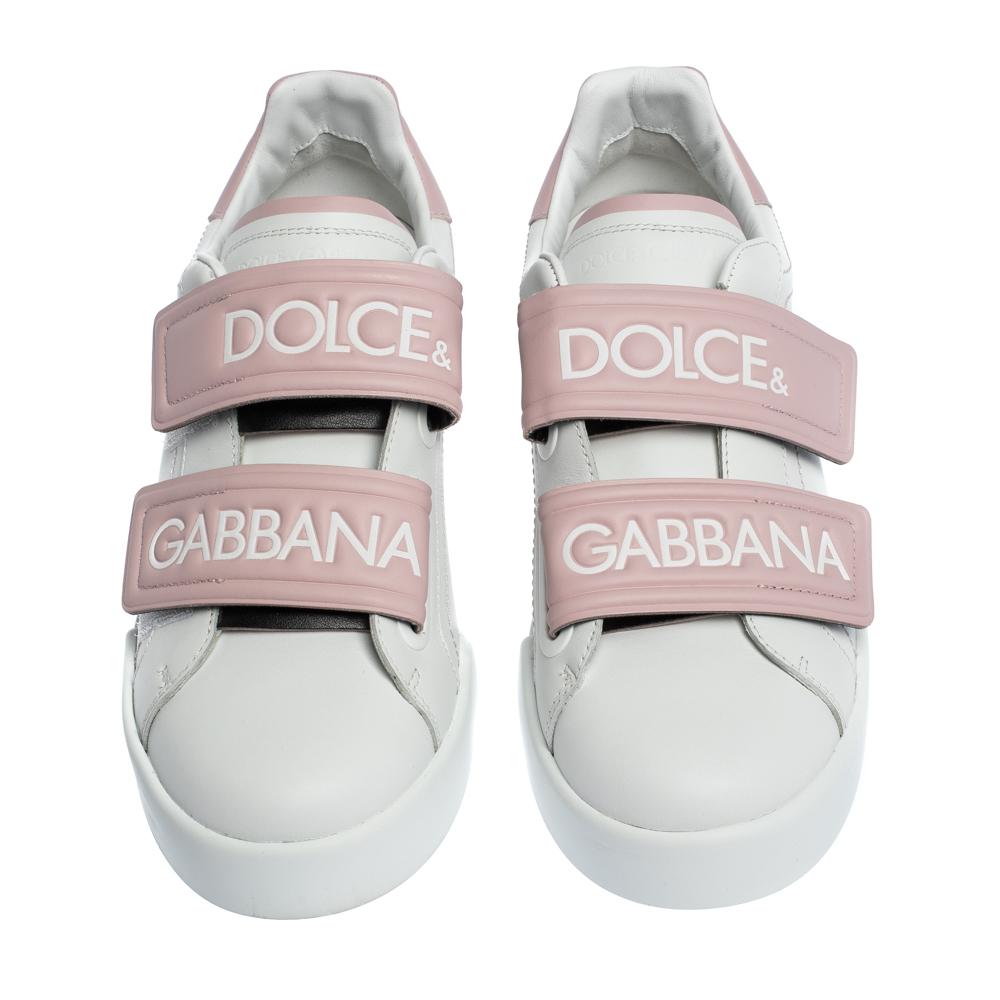 Get a head start on trending styles with these fashion-forward Dolce & Gabbana sneakers. Featuring Velcro straps accented with Dolce & Gabbana logo, these white and pink sneakers are the epitome of chic. Crafted from leather, these sneakers are