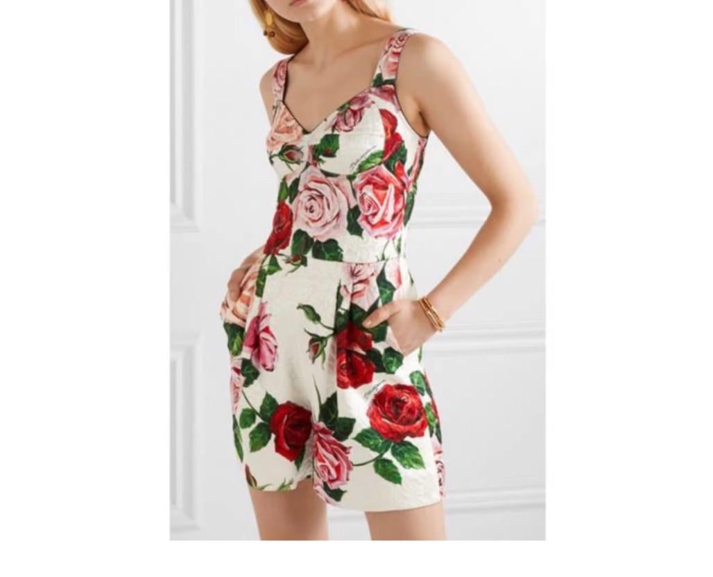 Romantic roses have become an intrinsic part of Dolce & Gabbana’s exuberantly feminine collections; gracefully decorating clothing and accessories, each bloom is beautifully brought to life. This white cotton blend rose print jumpsuit from Dolce &