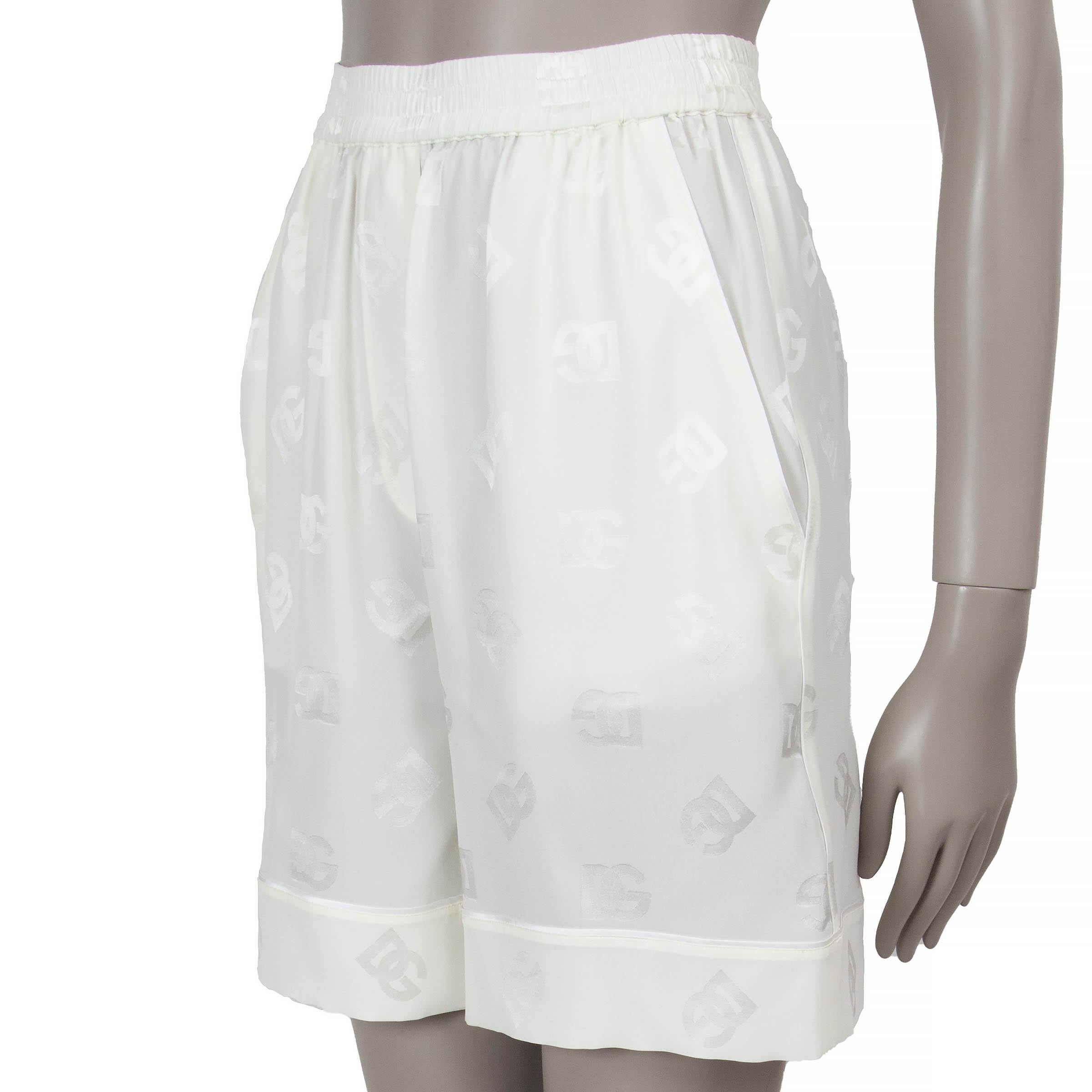 Diese 100% authentischen Bermudashorts von Dolce & Gabbana aus cremefarbener Jacquard-Satinseide (100%) sind mit einem Allover-Logo-Muster verziert und verbinden Komfort und Eleganz. Sie haben eine entspannte Silhouette, weite Beine, zwei