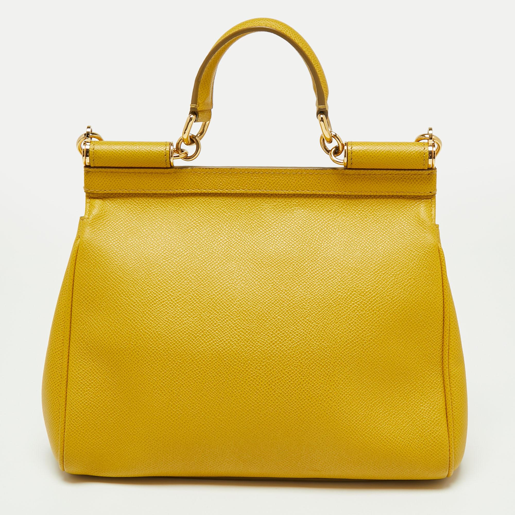 This gorgeous yellow Miss Sicily bag from Dolce & Gabbana is a handbag coveted by women around the world. It has a well-structured design and a flap that opens to a compartment with fabric lining and enough space to fit your essentials. The bag