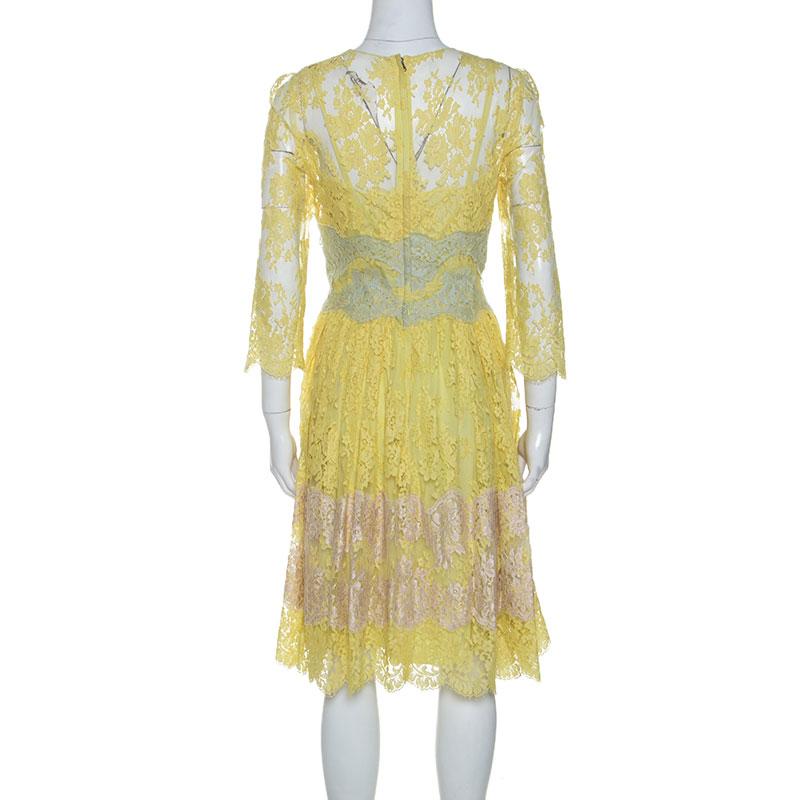 This stylish yellow dress by Dolce & Gabbana is stunning and versatile. Crafted from a cotton blend, it is adorned with lace throughout. This midi dress features three-quarter sleeves, a round neck, a-line silhouette, back-zip closure, and a good