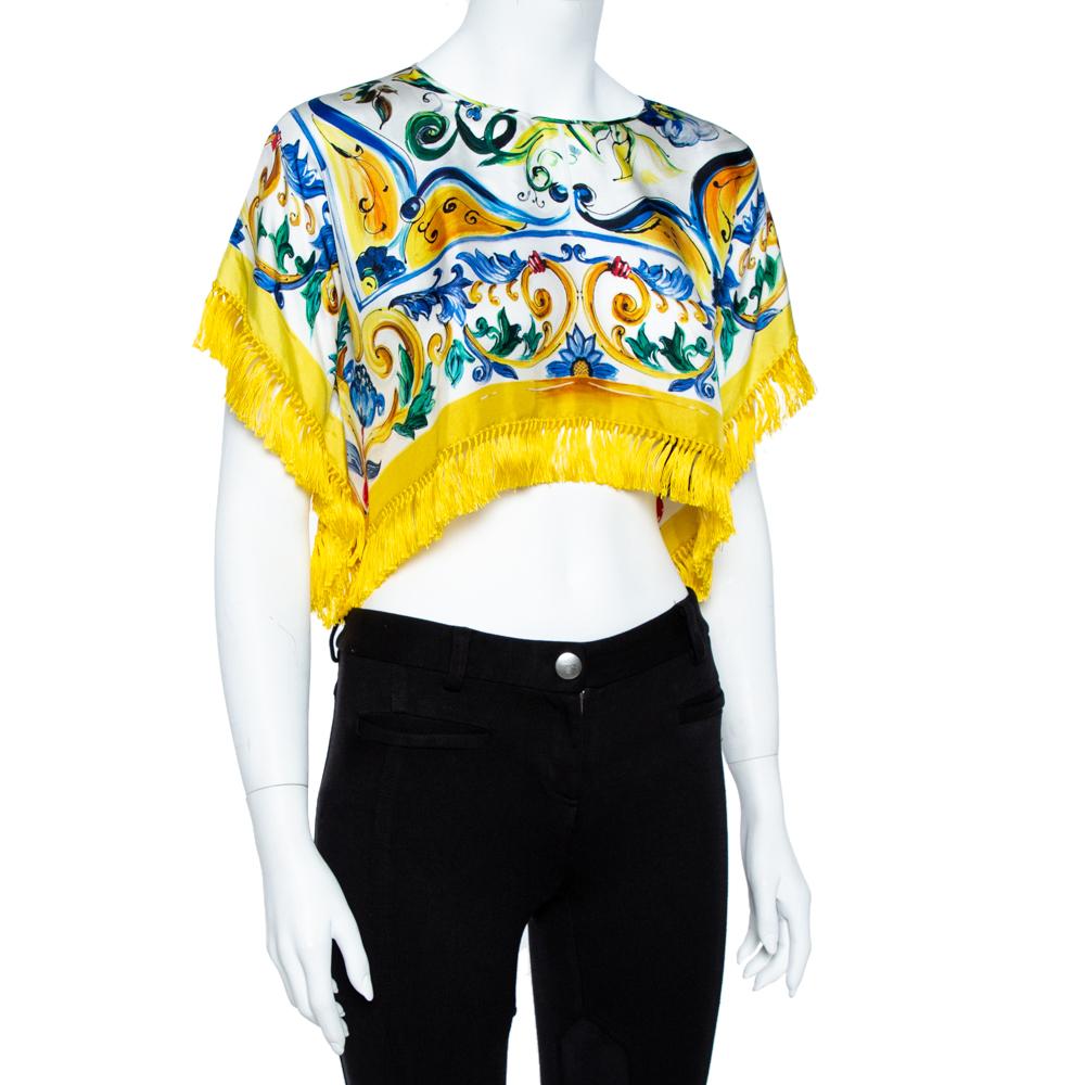This playful and colorful crop top hails from the house of Dolce & Gabbana. It has been crafted from luxurious silk and carries a yellow-hued Majolica print throughout. It has a round neck, fringed detailing along the hemline & sleeves and a good