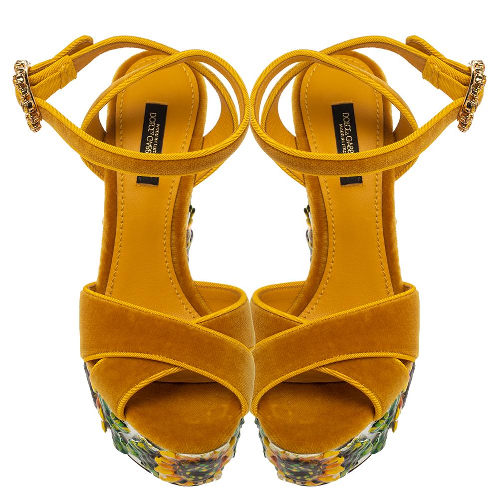 Diese gelben Sandalen von Dolce & Gabbana sind ein wahrer Augenschmaus, da sie die romantische Ästhetik der Blumen aufgreifen. Die Riemen sind aus Samt und mit Kristallen an der Schnalle verziert. Die Plateaus und die 14 cm hohen Absätze sind mit