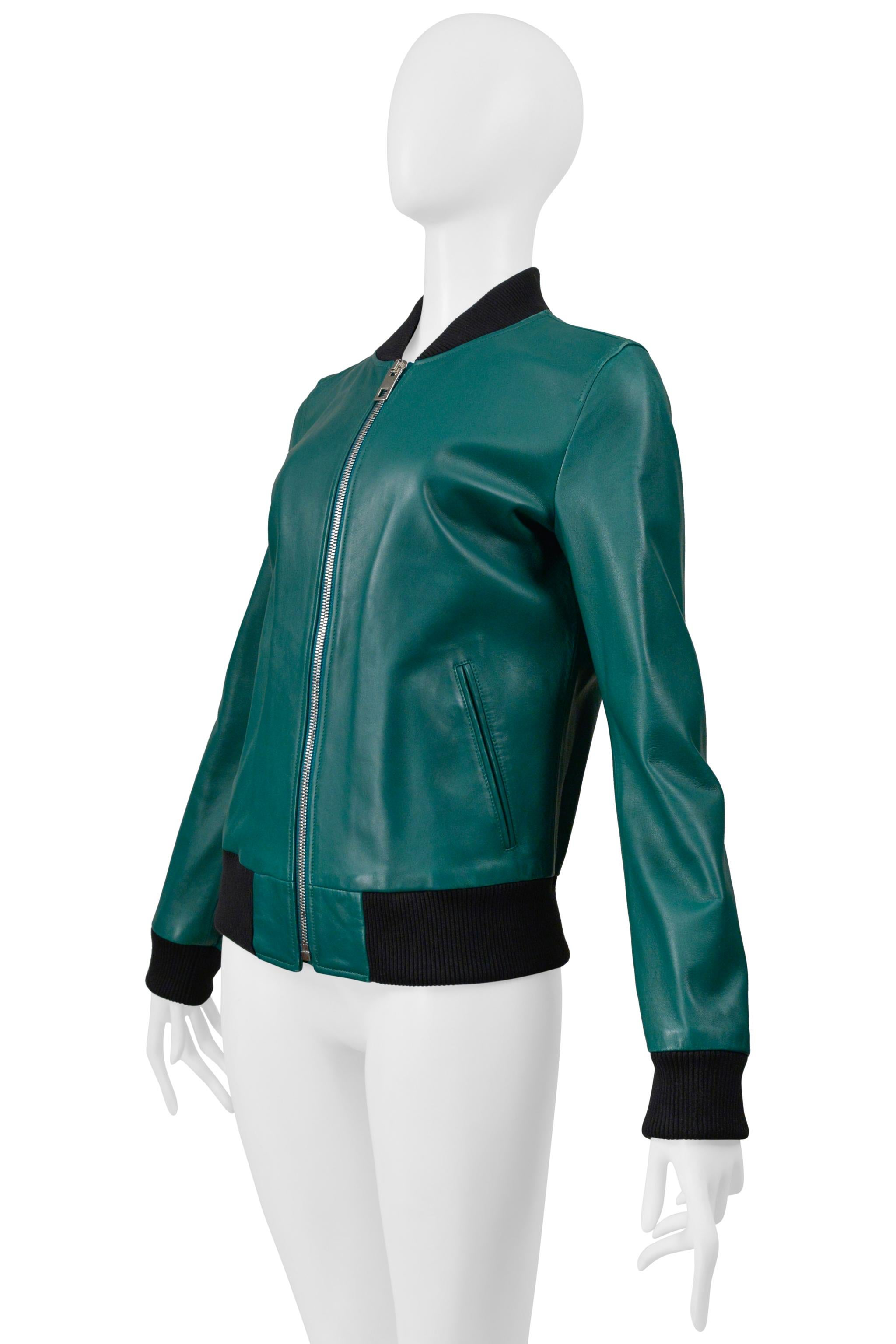 Resurrection Vintage a le plaisir de vous proposer une veste bombardier vintage Dolce & Gabbana en cuir vert avec bordures côtelées noires, avec poches latérales fendues, doublure intérieure, fermeture éclair embossée 