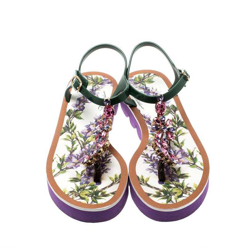 These fabulous sandals from Dolce & Gabbana are crafted from rubber and feature floral prints on the insoles. They flaunt crystals incorporated into the T-strap design and buckle ankle straps. This pair is worthy of being a part of your