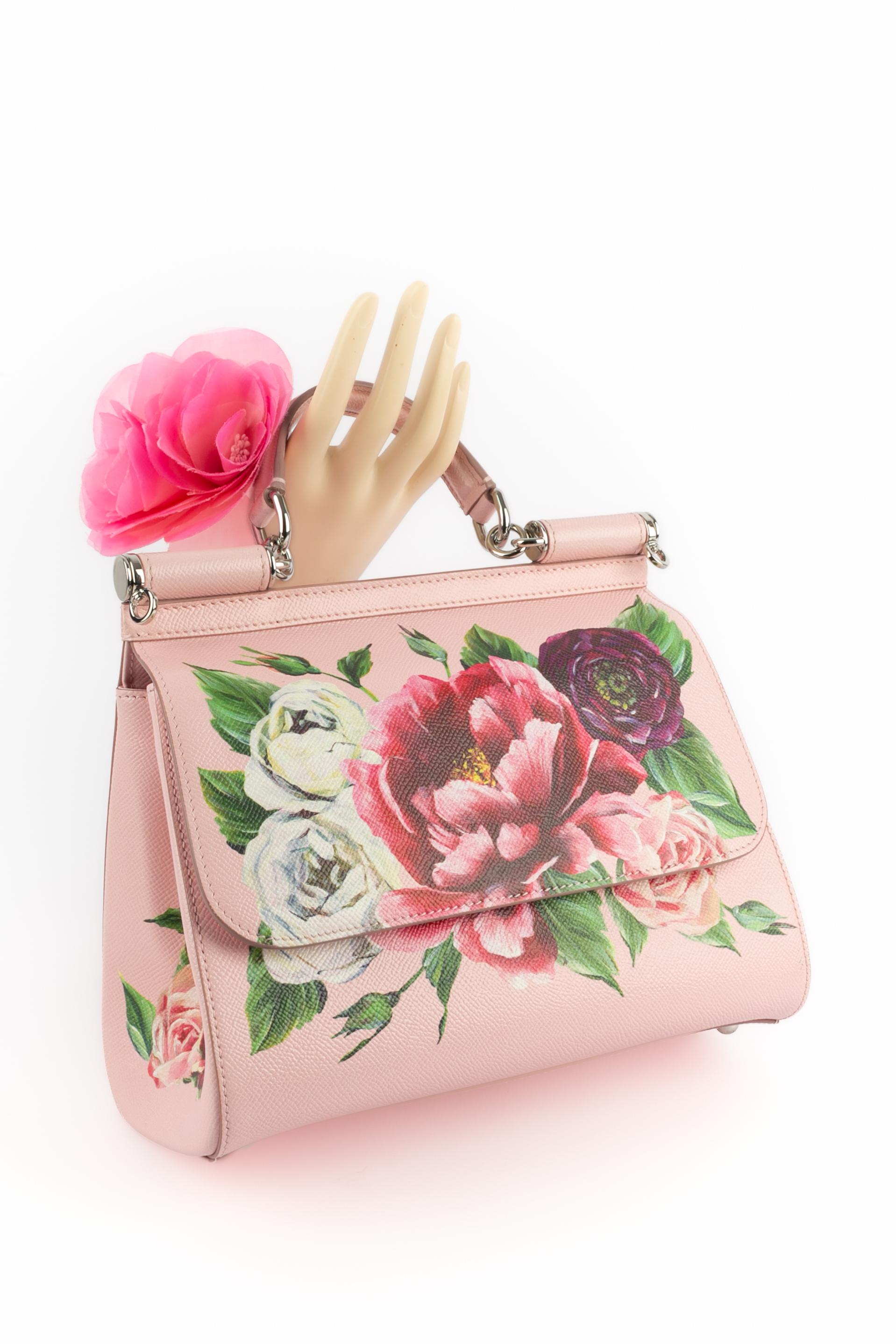 DOLCE&GABBANA - (Fabriqué en Italie) Sac 'Sicily' en cuir grainé rose imprimé d'un motif floral multicolore. Fermeture magnétique, poignée, bandoulière réglable et amovible.

Condit :
Très bon état.

Dimensions :
Hauteur : 21 cm - Largeur : 25 cm -