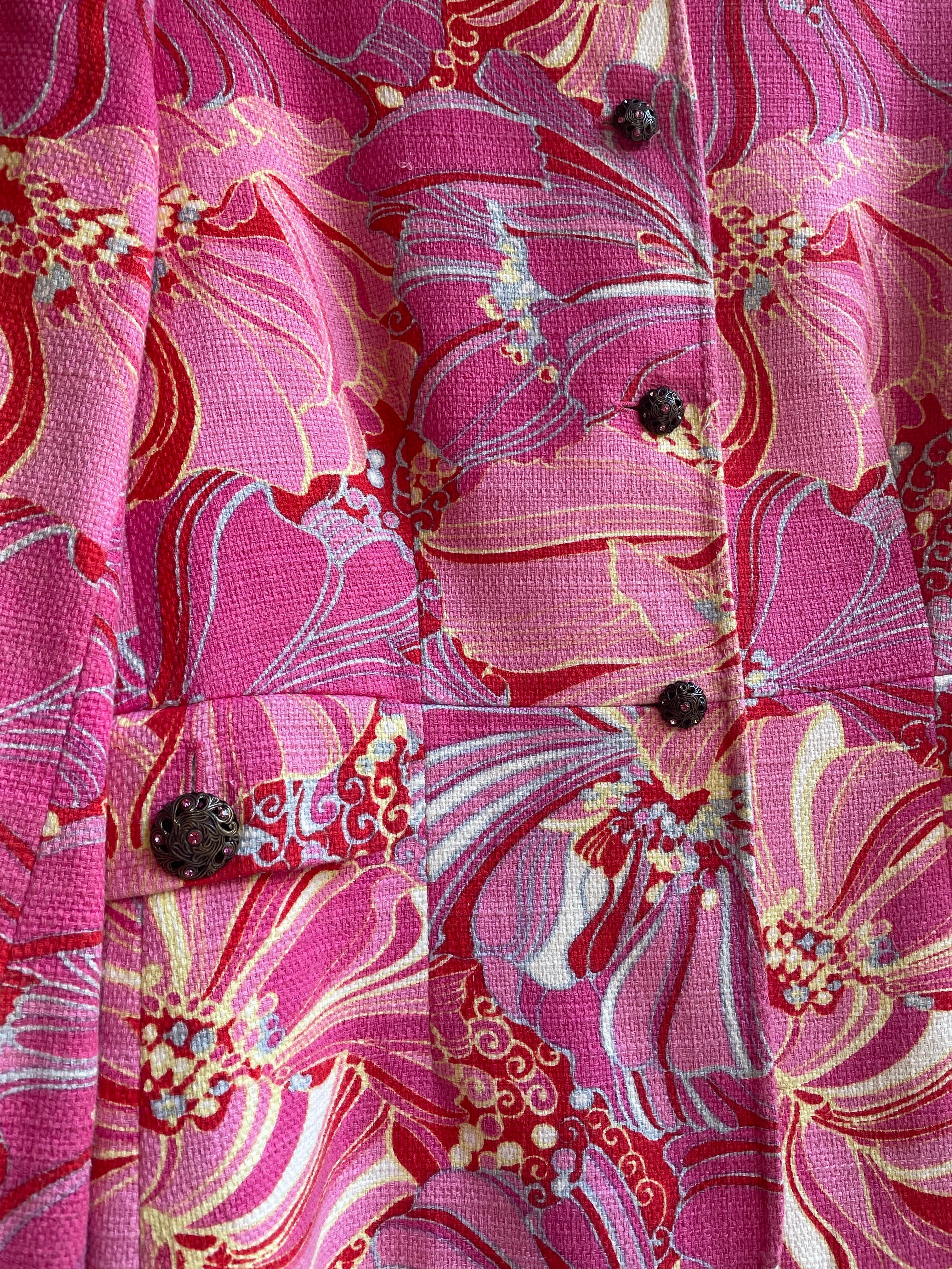 Dolce&gabbana Jacke in Rosatönen mit Blumenmuster und Juwelenknöpfen. 
100% Leinen Größe 44.
Leicht gepolsterte Schultern. 
Schultern 42 cm
Hülse 55 cm
Oberweite 46 cm
Taille 44cm
63 cm lang 
Es hat einige kleine Gebrauchsspuren wie einige gezogene