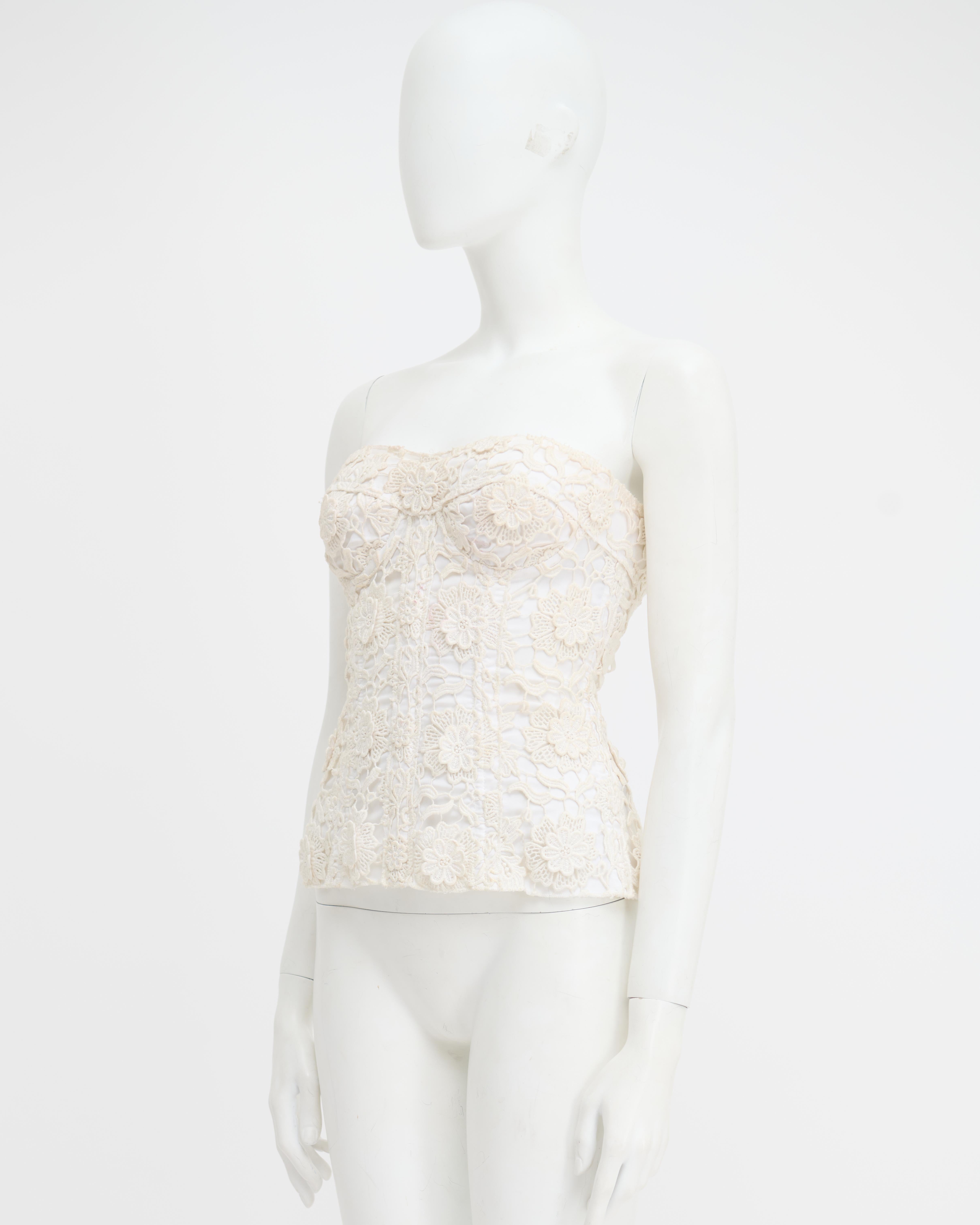 - Designed by Dolce&Gabbana
- Sold by Skof.Archive
- White floral lace corset
- Spring Summer 2006 collection
- Features intricate floral lace detailing
- Boned structure
- Strapless design with a sweetheart neckline
- Laced Up closure on the back
-