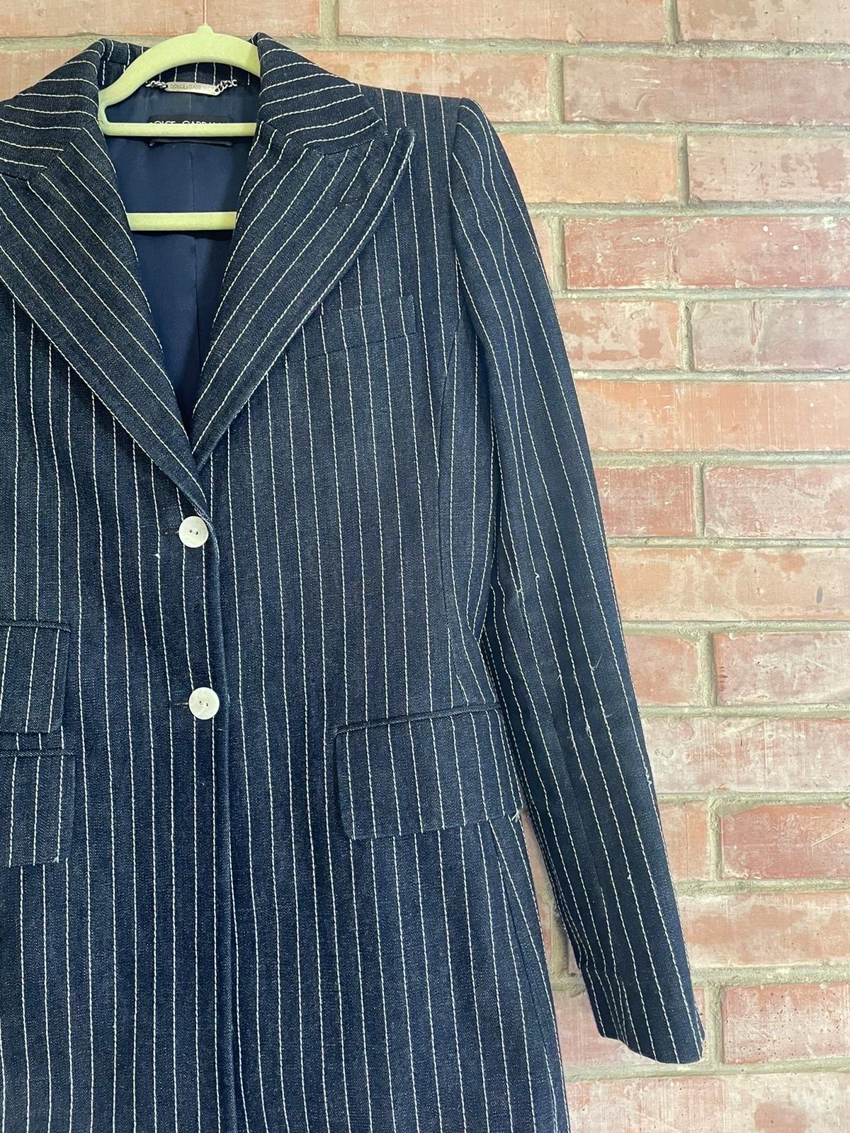 Dolce&Gabbana suit with jacket and trousers in 100% cotton with pinstriped denim effect. 
Jacket closed with two branded mother-of-pearl effect buttons. Lightly padded shoulders. 
Trousers closed by zip and two buttons identical to the jacket. 
Size