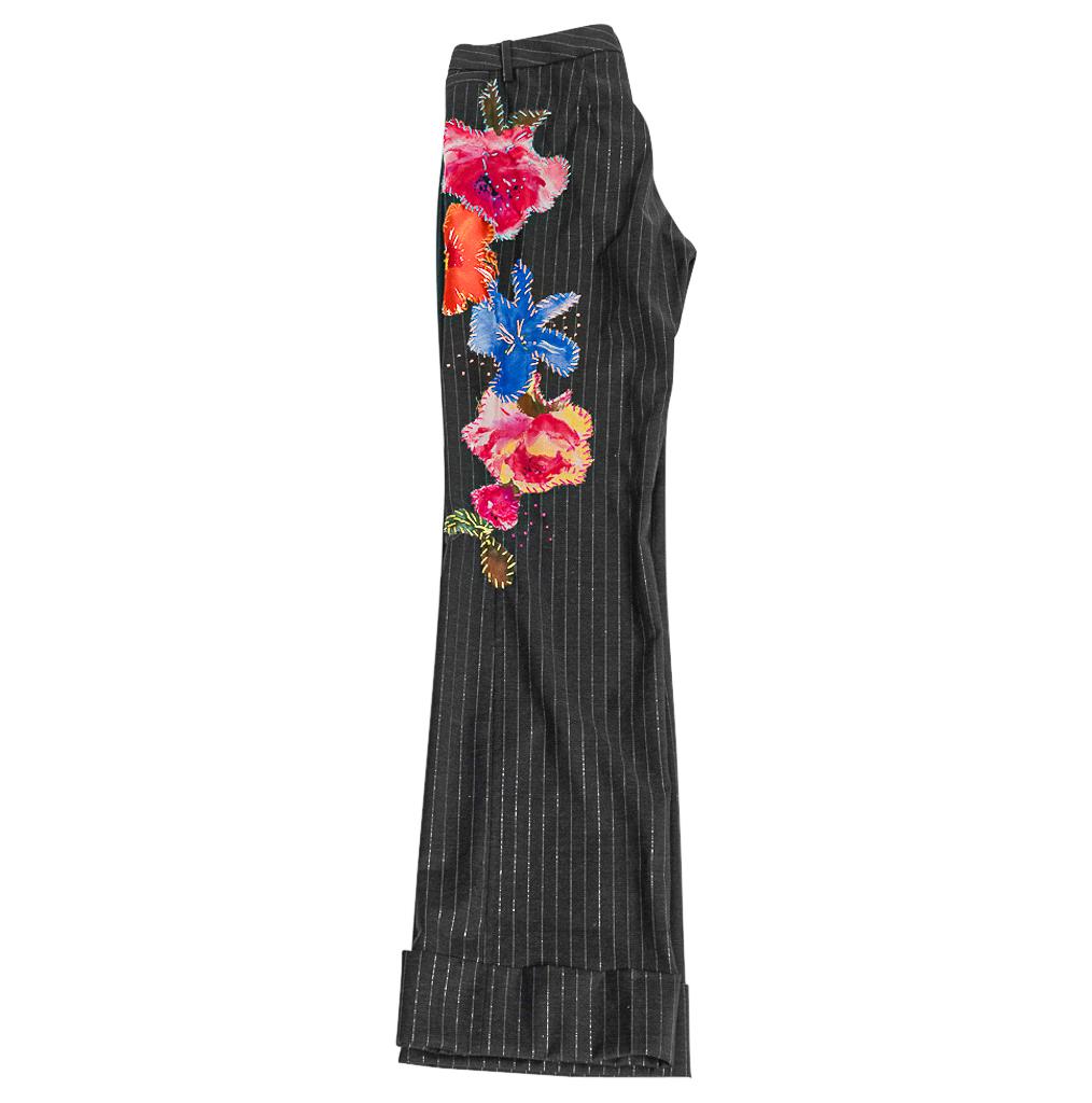 Guaranteed authentic Dolce&Gabbana vintage gray pin striped pants with silk flower appliques.
Subtle metallic silver pin stripes against a charcoal gray light weight wool fabric.
Pant has 5 floral appliques down the left leg that wrap front to