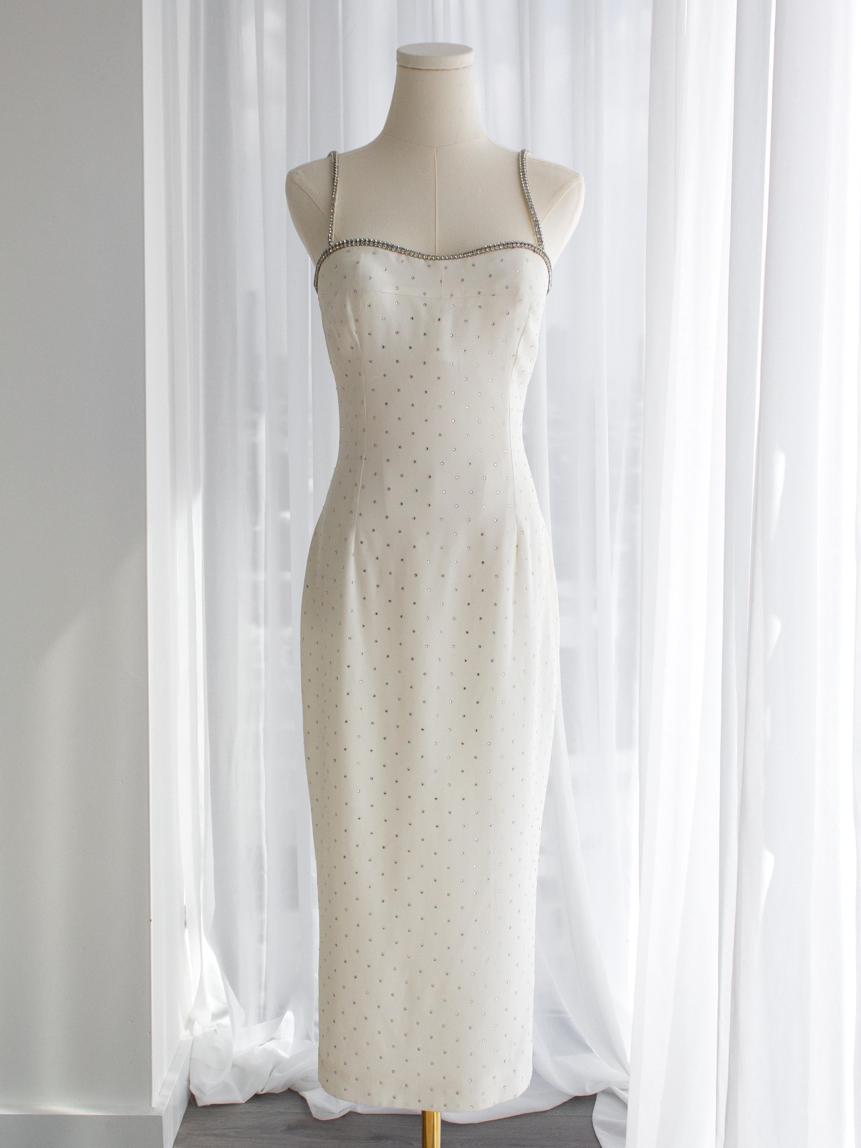 Introducing an exceptionally rare find: a white crystal dress from Dolce&Gabbana's Spring/Summer 1995 collection. Famously worn by Monica Bellucci, Brooke Shields, Celine Dion and Madonna at the 1995 Oscars. This exquisite garment is lavishly