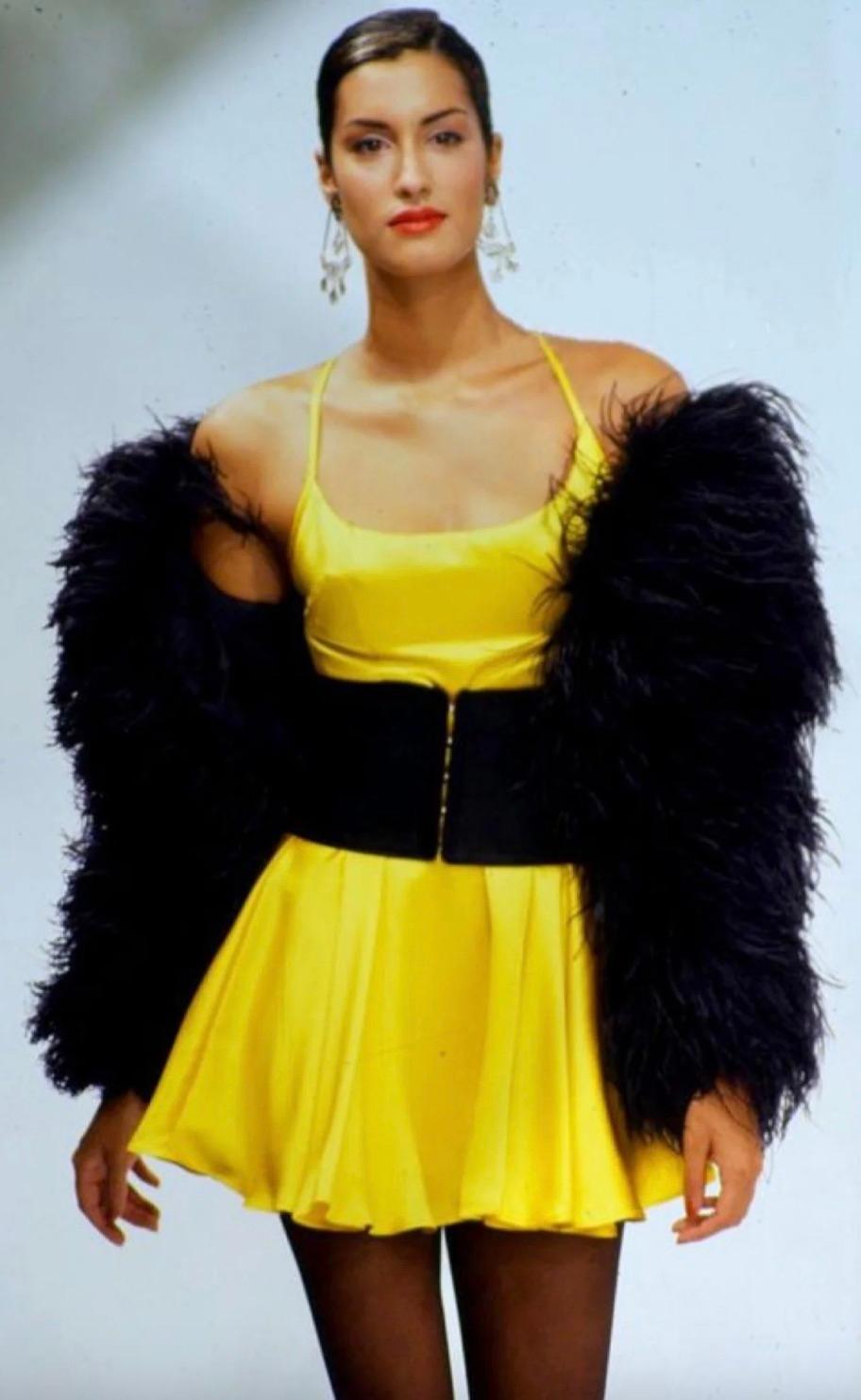 A standout piece from Dolce & Gabbana's Spring/Summer 1995 collection, this yellow satin mini skater dress is both chic and playful. It features a flattering flared skirt, stylish cross-back straps, and a discreet side zipper for easy wear.
In good