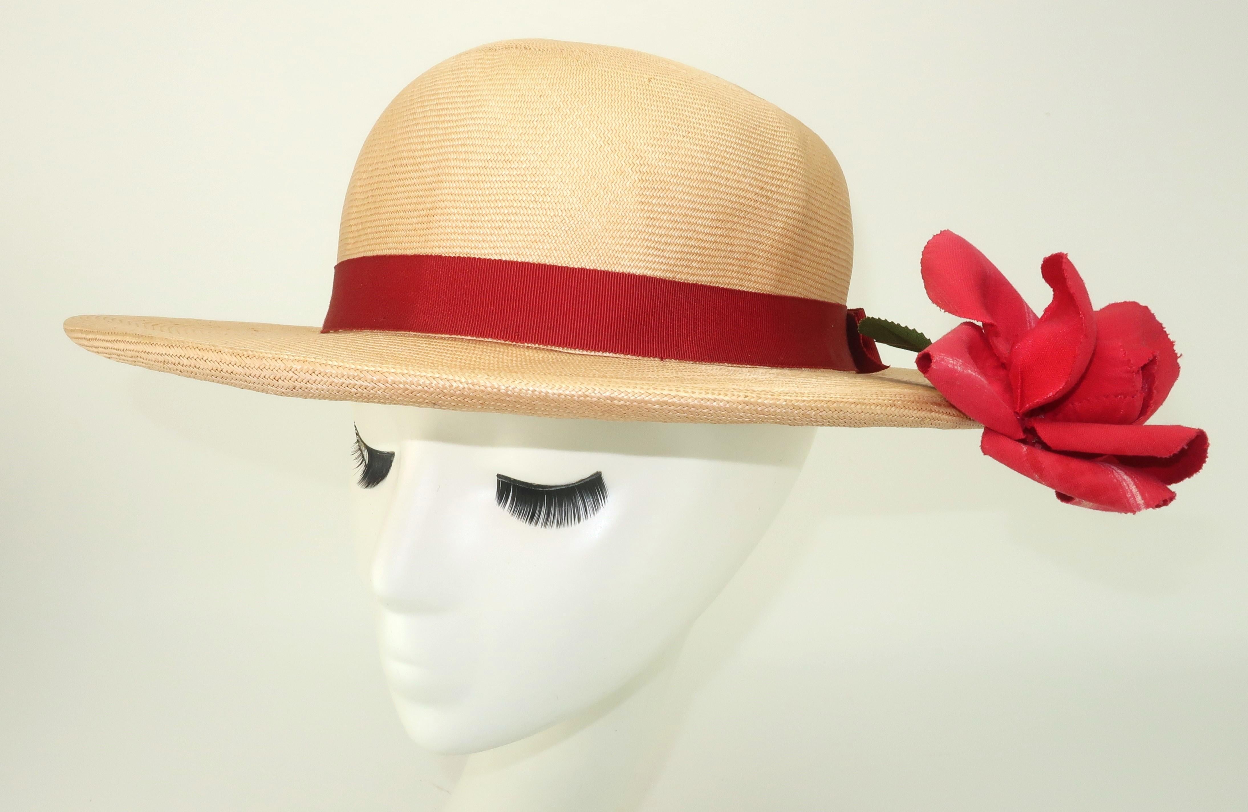 1950’s Dolly Madison natural straw hat with red grosgrain band and bow accented with a red rose.  This clever hat has a charming surprise … the rose appears to be growing from under the brim with just a hint of green leaves and a stem (yes, that