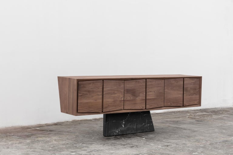 This sideboard or credenza, made of solid walnut wood, has a base of Monte Negro black marble. The sideboard is from our Dolmen Collection. 
 