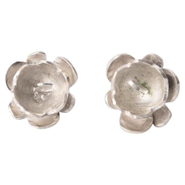 Célébrez la beauté enchanteresse de la Patagonie avec ces boucles d'oreilles en forme de fleur de Calafate, délicatement fabriquées à la main en argent 925. Inspirées par les délicates fleurs de l'arbuste Calafate, une plante originaire des régions