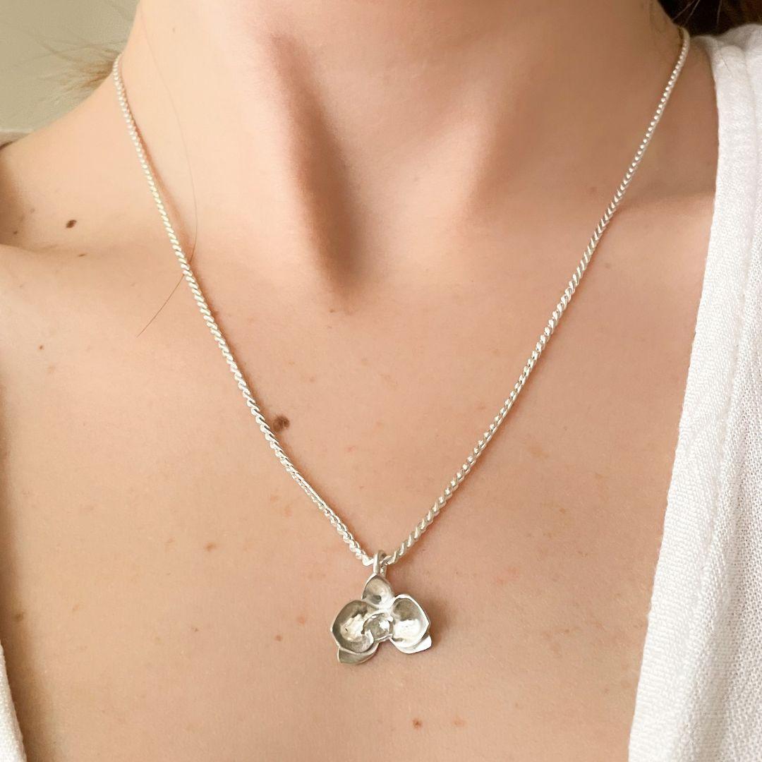 This handcrafted Orchid Pendant Necklace by Dolores Ortega is a sophisticated piece from the “El Poder de las Flores” collection. Expertly crafted in 925 sterling silver, the design is inspired by the graceful and exotic orchid flower. Known for its