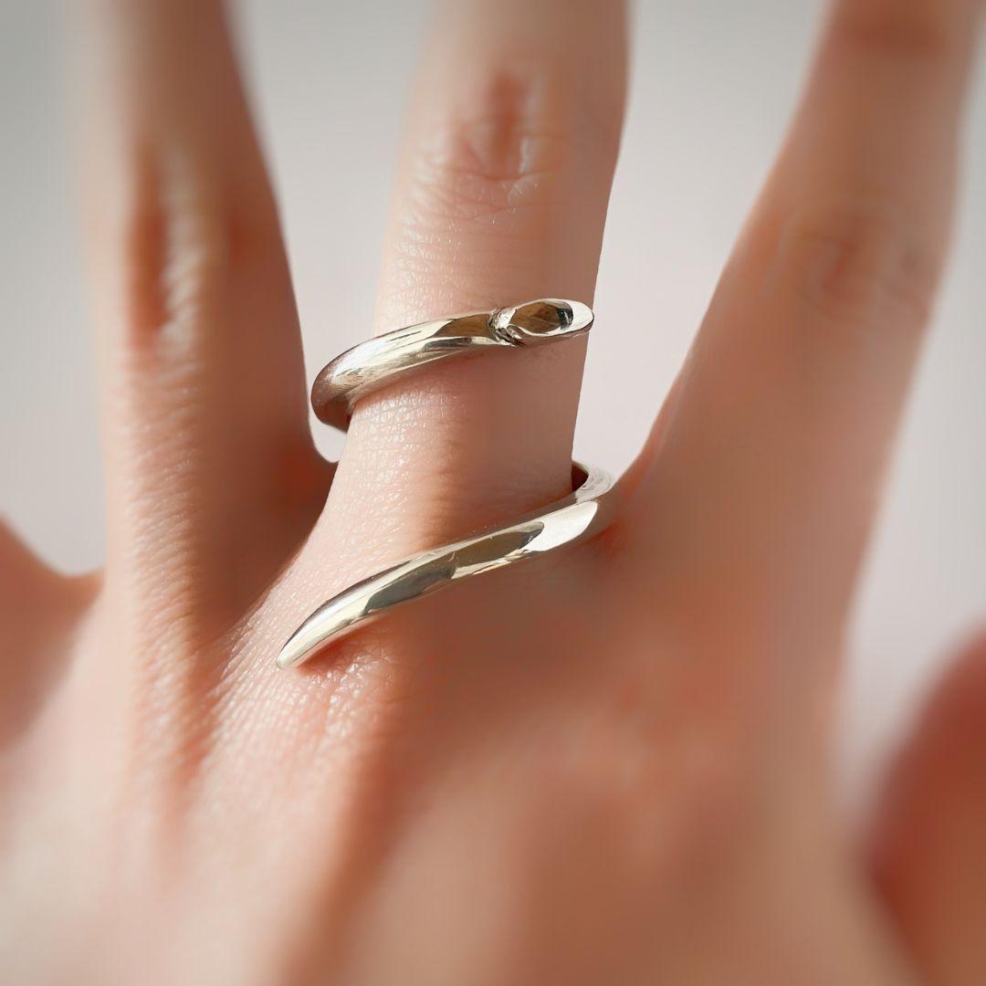 Dieser handgefertigte Ring aus 925er Sterlingsilber besticht durch seine schlichte Eleganz und sein zartes Schlangenmotiv, das sich raffiniert um den Finger legt. Inspiriert von der Schlange als Symbol für Verwandlung, Erneuerung und Intuition, ist