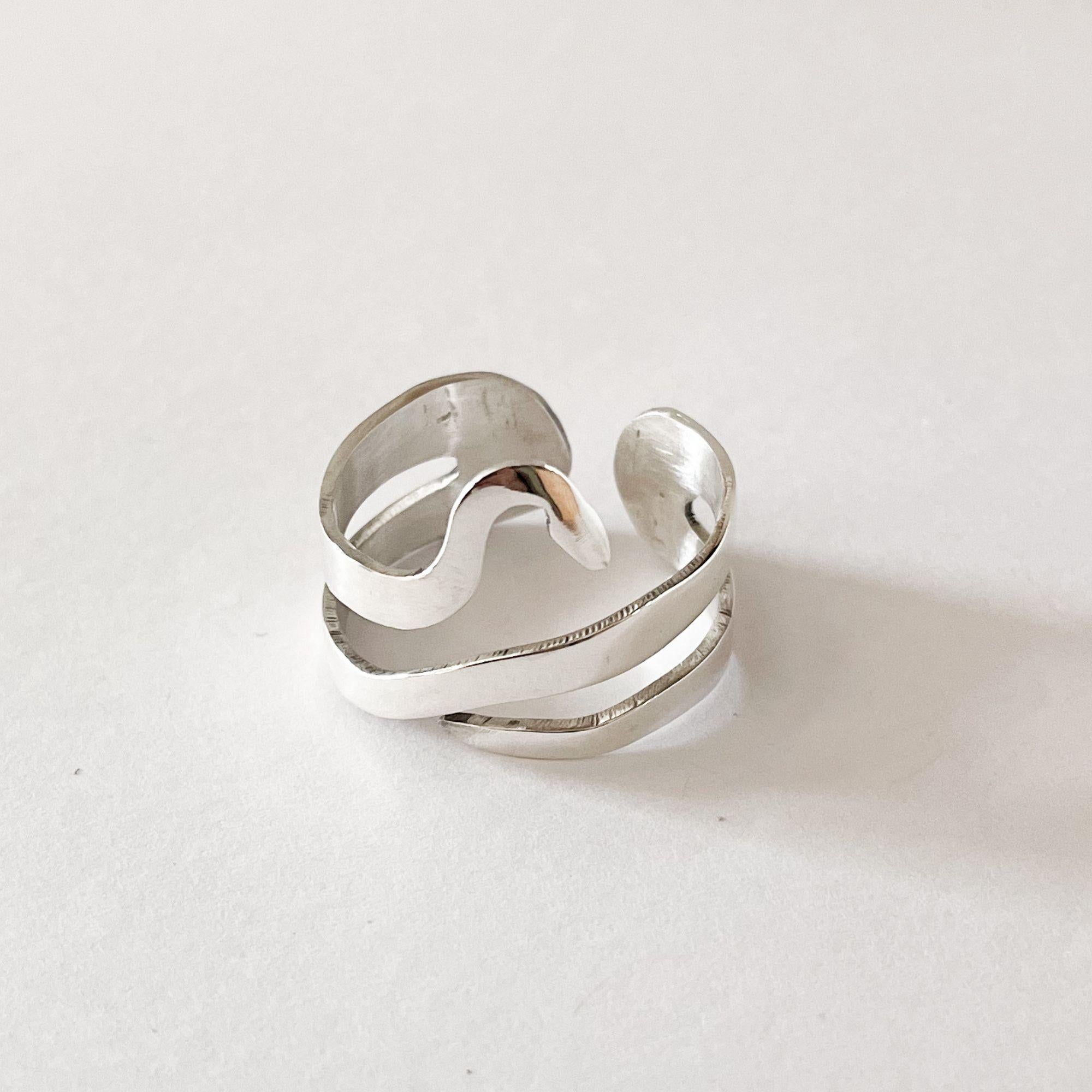 Questo anello regolabile realizzato a mano in argento sterling 925 sfoggia un design a serpente minimalista ma potente. Ispirato a uno dei ciondoli simbolo di Dolores Ortega, il serpente si arrotola a forma di simbolo dell'infinito, emblema di