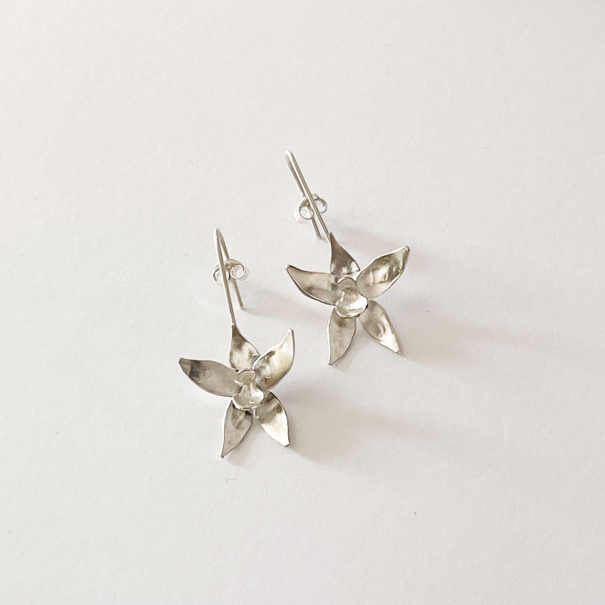 Questi orecchini artigianali in argento sterling si ispirano alla delicata eleganza delle orchidee selvatiche, simbolo di forza, bellezza e raffinata femminilità. Scolpito interamente a mano, ogni orecchino mostra la graziosa silhouette di un fiore