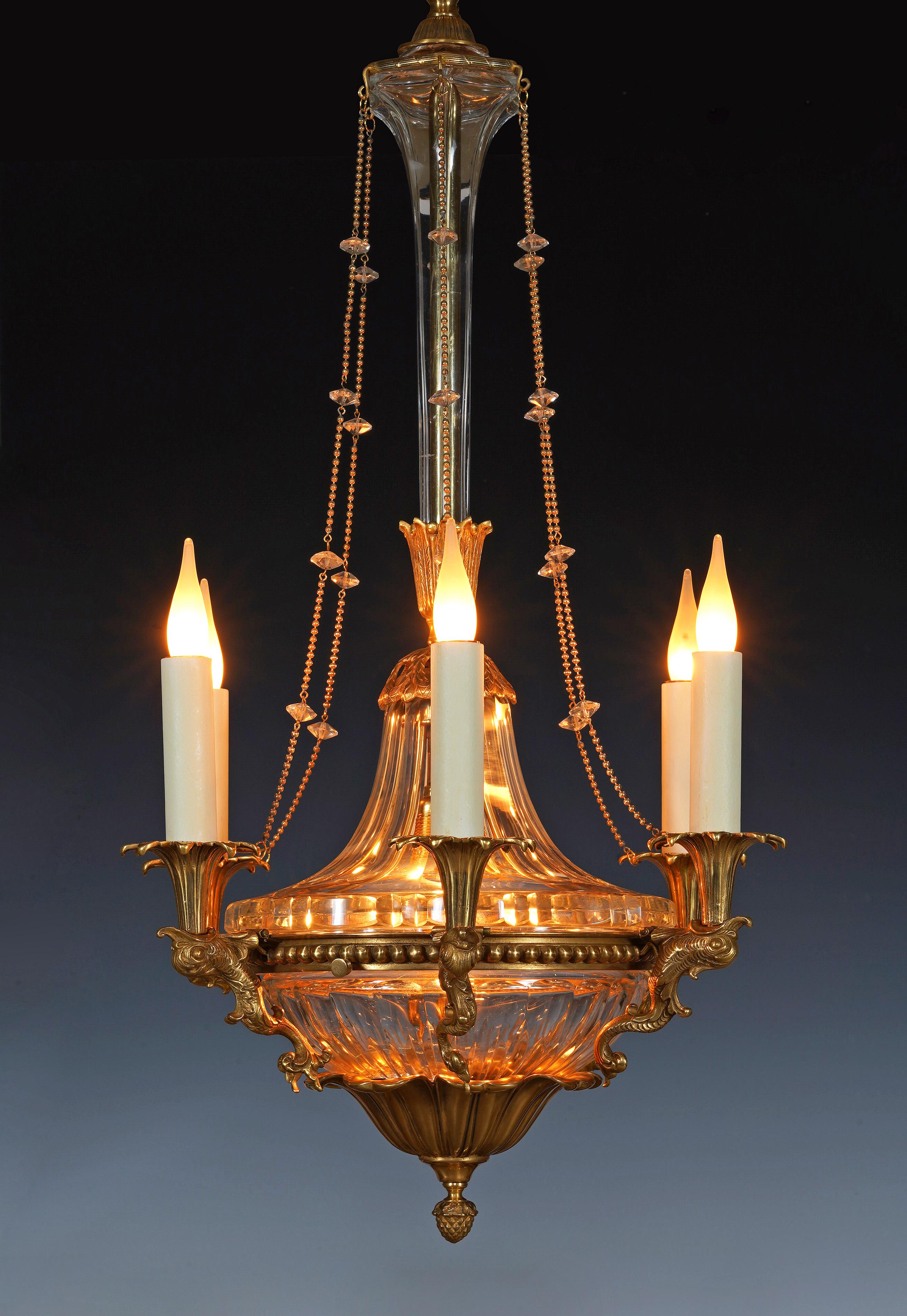 Seltener Kronleuchter im Louis-XVI-Stil aus Kristall und ziselierter und vergoldeter Bronze mit sechs Lichtern. Er besteht aus einem beleuchteten Becken aus geschliffenem Kristall, das am Boden mit großen Blättern bedeckt ist, die in einem Samen