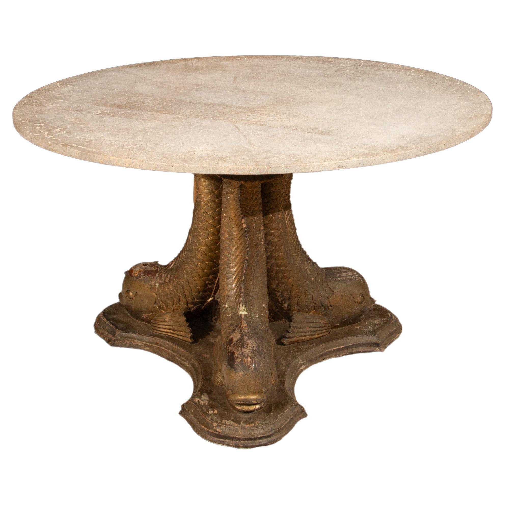 This exquisite 19th-century round center or dining table is a remarkable example of fine craftsmanship, showcasing carved wood and gesso dolphins that serve as the table’s base. The intricate dolphin figures are expertly sculpted, with their