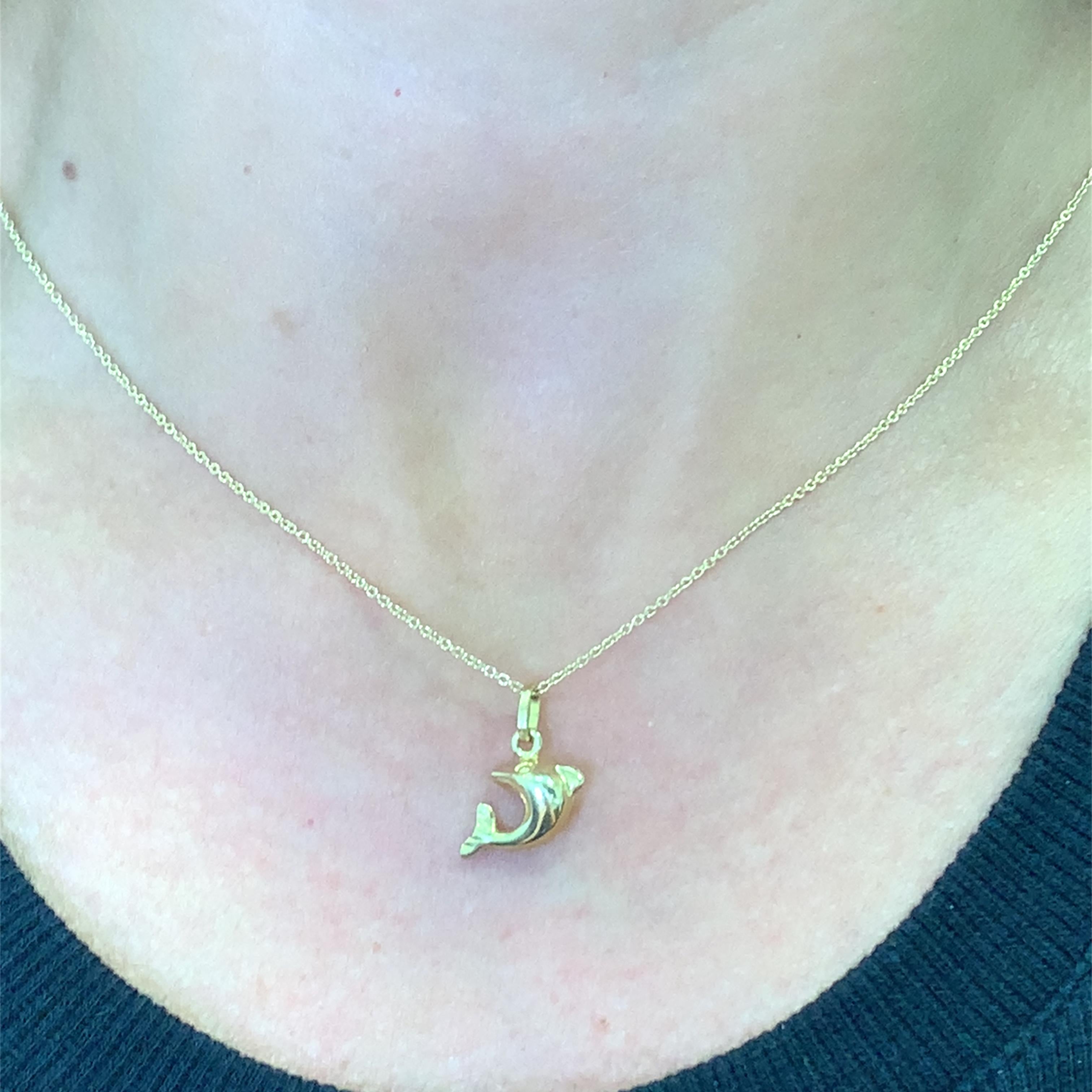 Tuffati nell'eleganza con questo stravagante ciondolo a forma di delfino in oro giallo. Questo giocoso pezzo cattura la grazia della vita marina, perfetto per aggiungere un tocco di fascino oceanico a qualsiasi ensemble. Una deliziosa dichiarazione