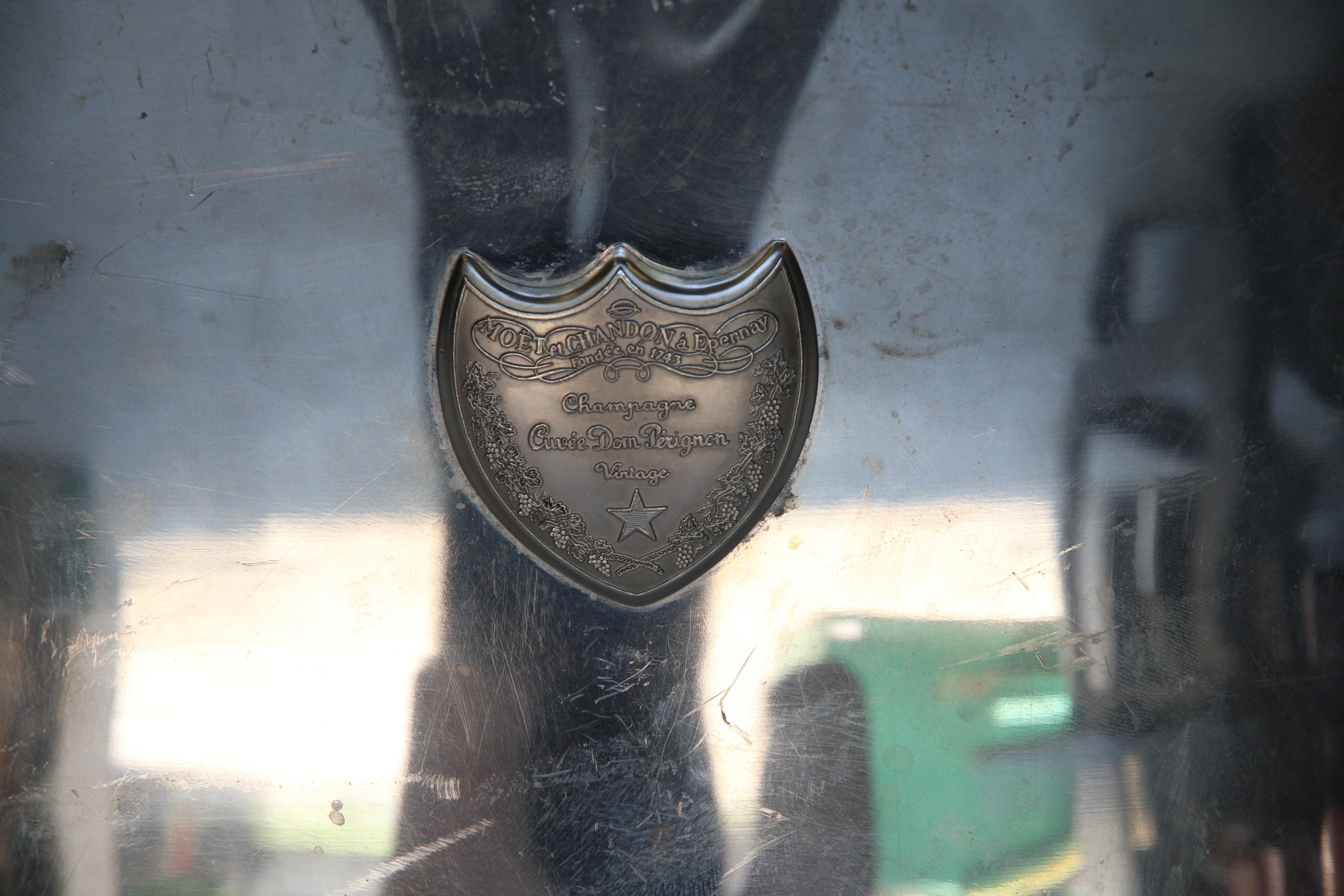 A beautiful Dom Perignon champagne cooler which will hold two bottles of bubbly. It has a Dom Perignon raised shield on both sides of the exterior and Dom Perignon inscribed on both sides of the interior. This piece was designed and signed by Martin