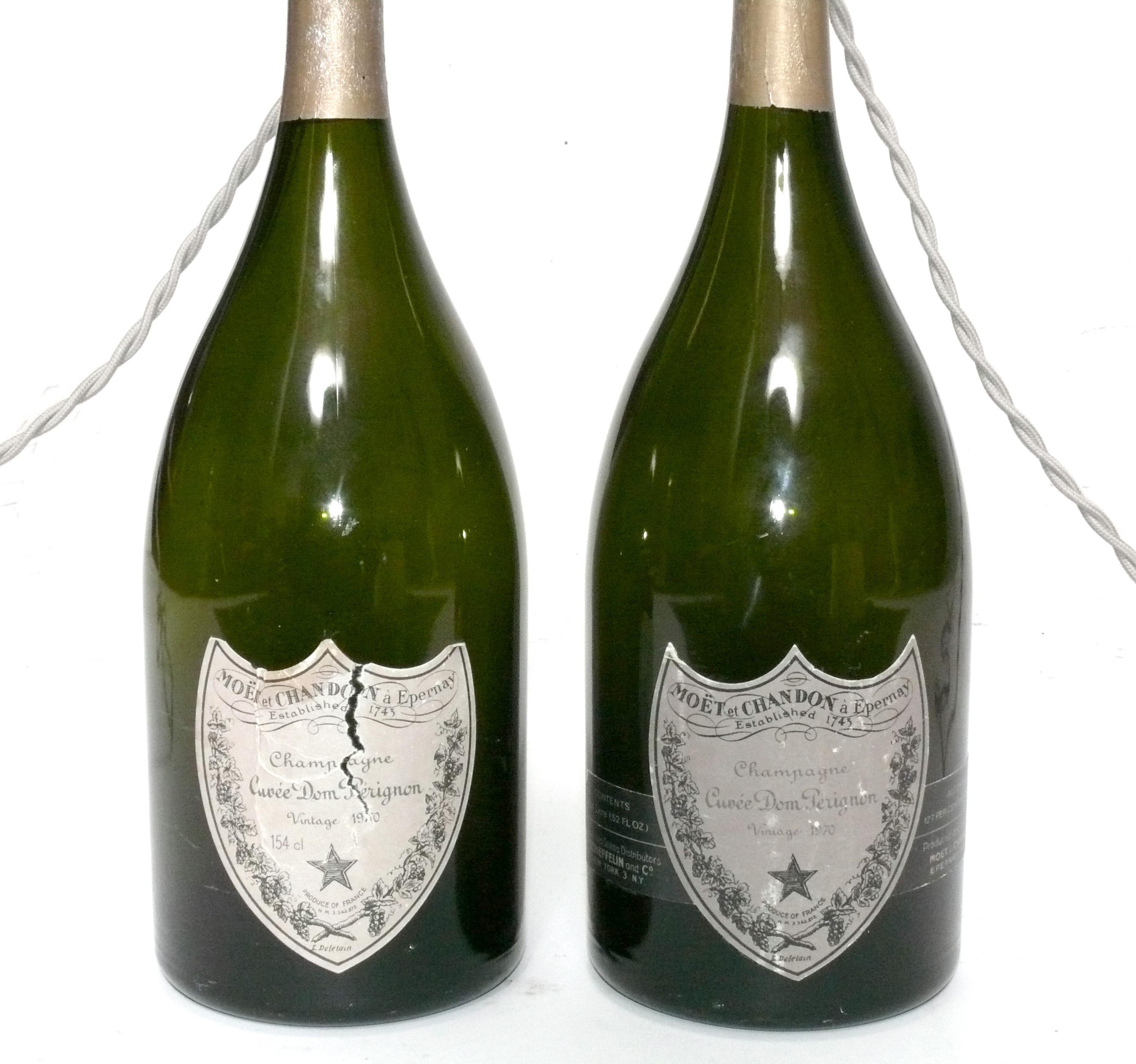 Vintage Dom Perignon Champagnerflaschen, ca. 1970er Jahre, Frankreich. Vor kurzem wurden sie mit silbernen, geflochtenen Stoffschnüren zu Lampen umfunktioniert. Die Lampen messen 17,75