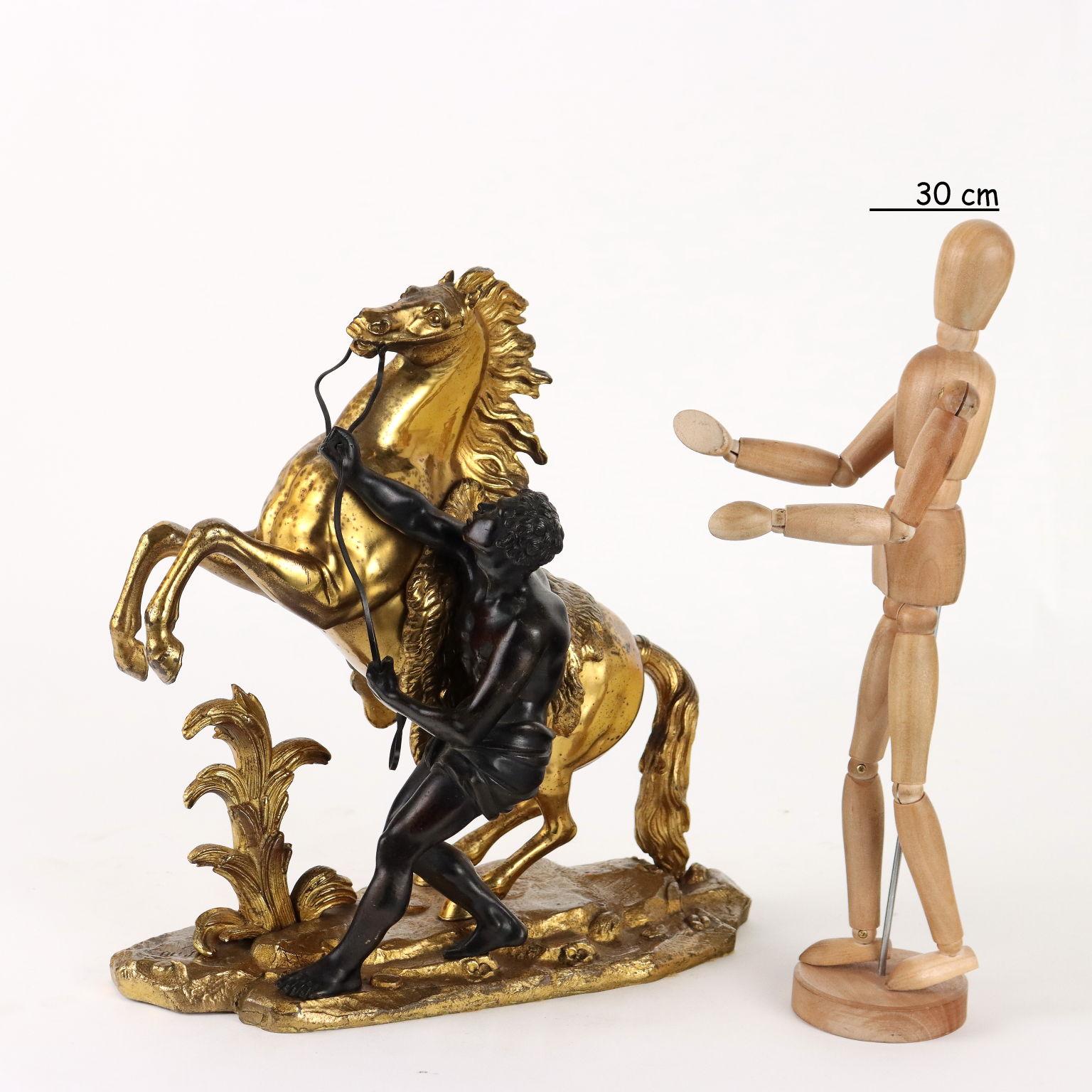 Scultura in bronzo dorato e brunito raffigurante domatore con cavallo. Sulla base firma incussa dell'autore. Copia postuma.