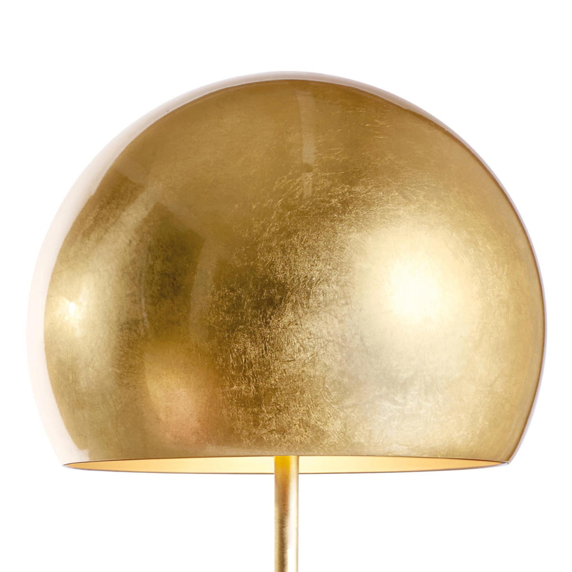 Lampe de table dôme feuille d'or avec base et pieds en fer
et avec un abat-jour en aluminium, le tout recouvert de feuilles d'or
et dans l'abat-jour intérieur verni à l'or. Avec 2 ampoules, lampe
support de type E27, max 60 watt. Ampoules non