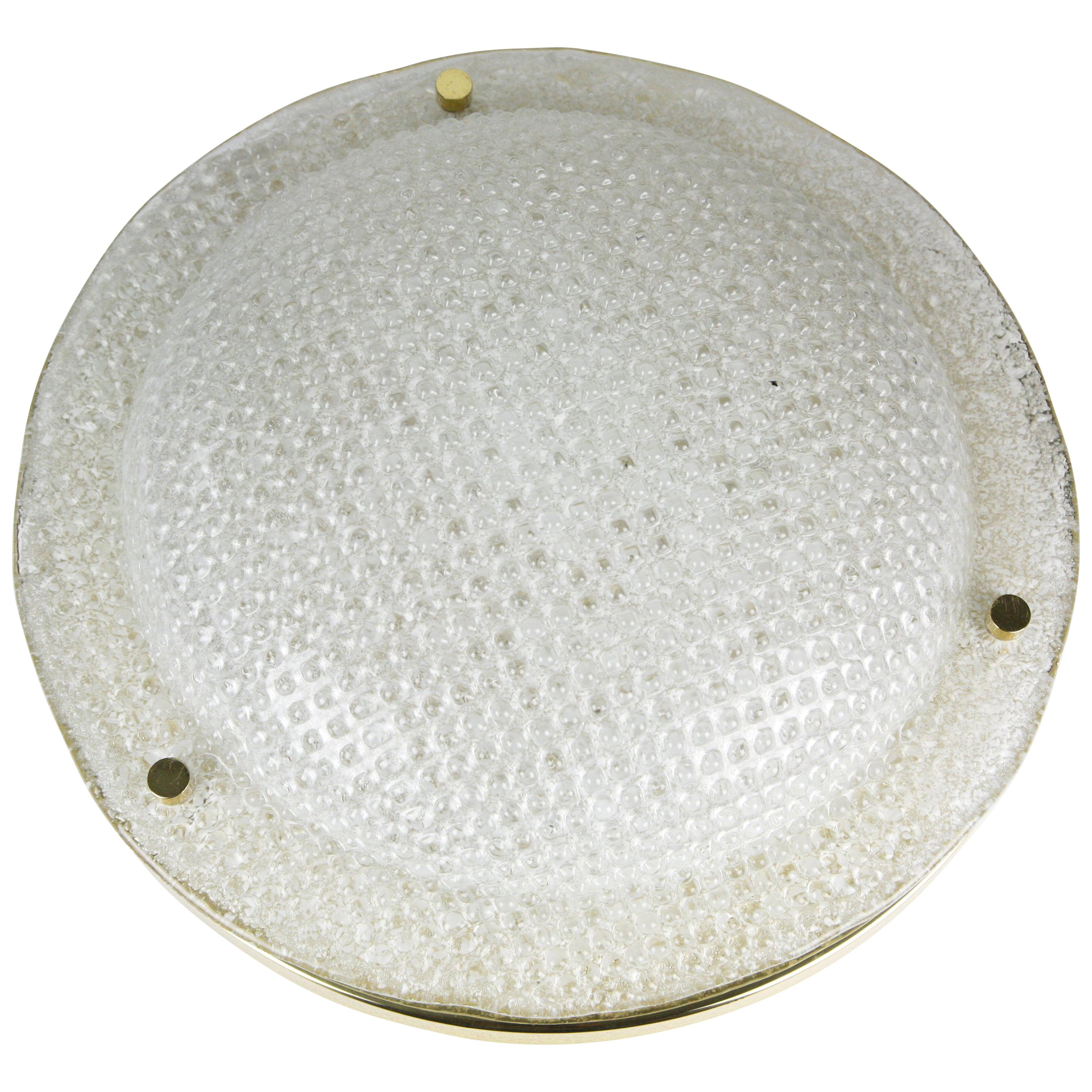 Dome shaped glass with waffle texture on a brass mount glass is lid up by four Edison ceramic sockets.
 