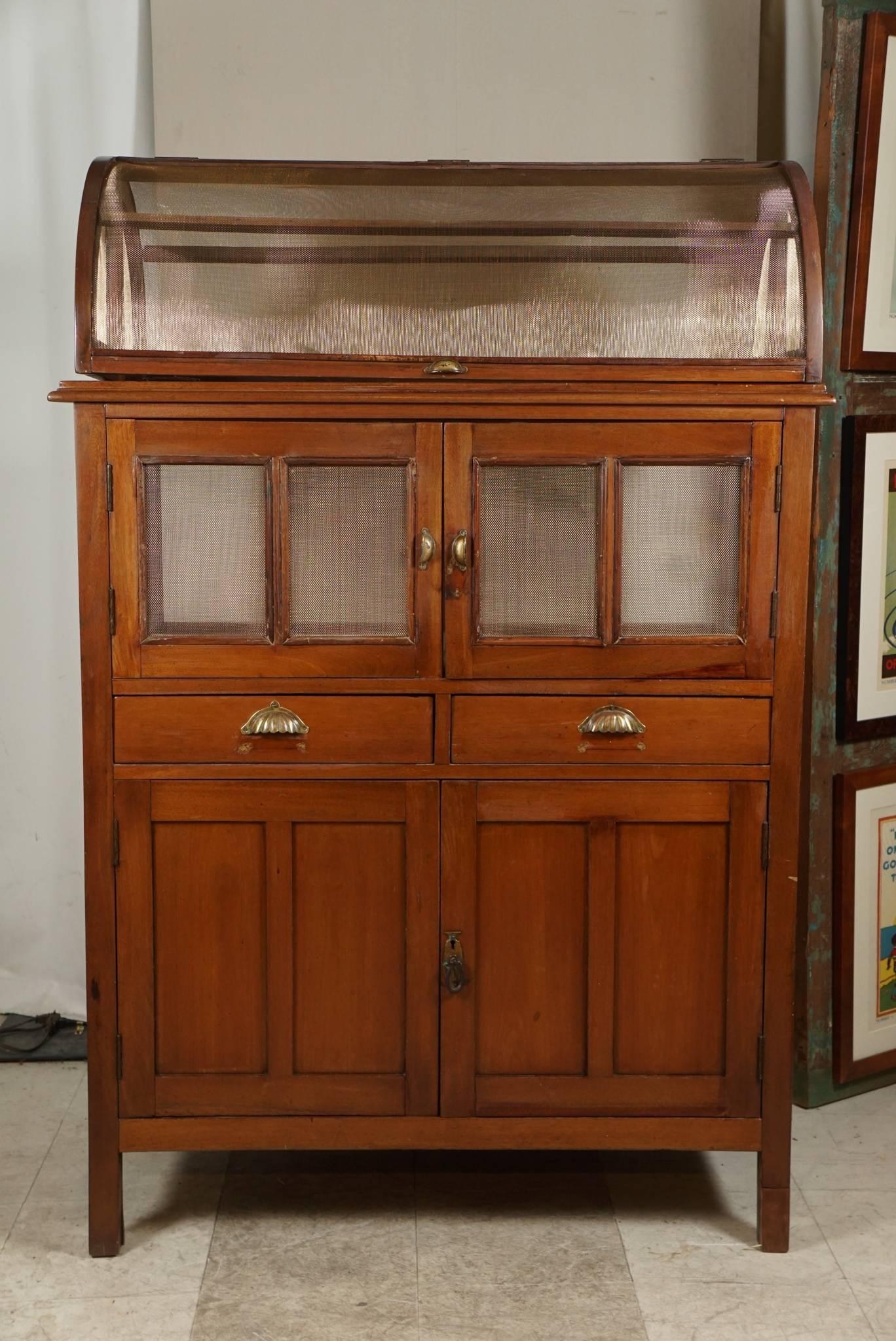 Une pièce inhabituelle. Cette armoire a été conçue pour éloigner les intrus. La grille en laiton permet la circulation de l'air. Beaucoup de rangement en haut et en bas.