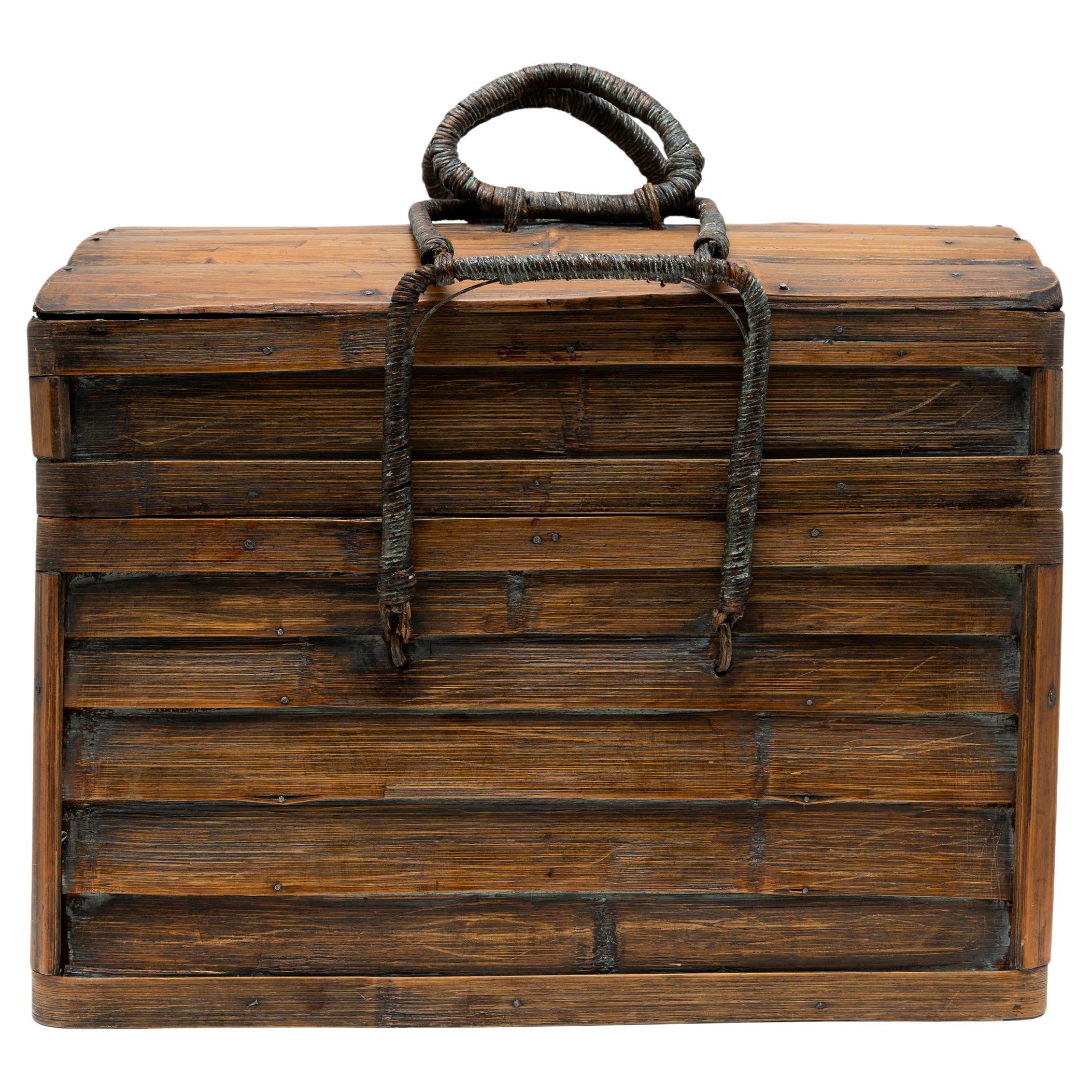 This rustic wooden chest is hand crafted of bamboo with ample space to store various household items. The chest opens by a hinged panel on the back, which drops downwards to reveal a large interior compartment. The chest is crafted with handles on