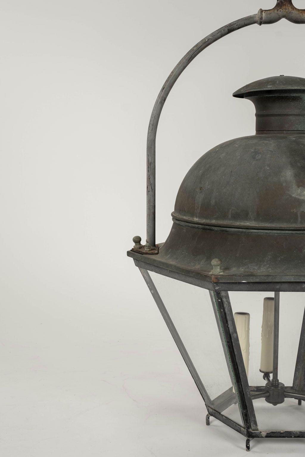 Domed hexagonal glass paneled iron and copper lantern, newly wired for use within the USA with drop cluster of three candelabra-size sockets. Lantern is from the South of France and dates to about the middle of 20th century. Includes four feet of