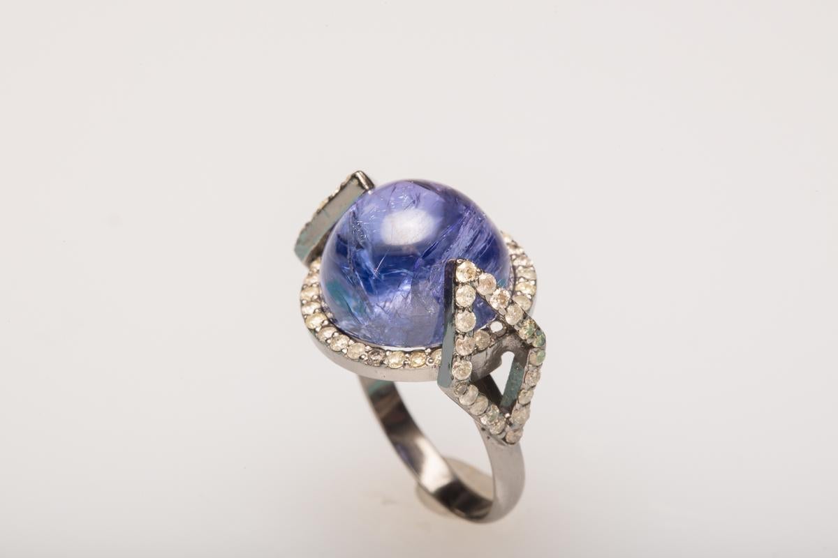 Large, domed cabochon tanzanite bordered in faceted diamonds set in sterling silver in an Art Deco design. Diamond weight is 1.4 carats, tanzanite is 16.20 carats.  Ring size is 6.5