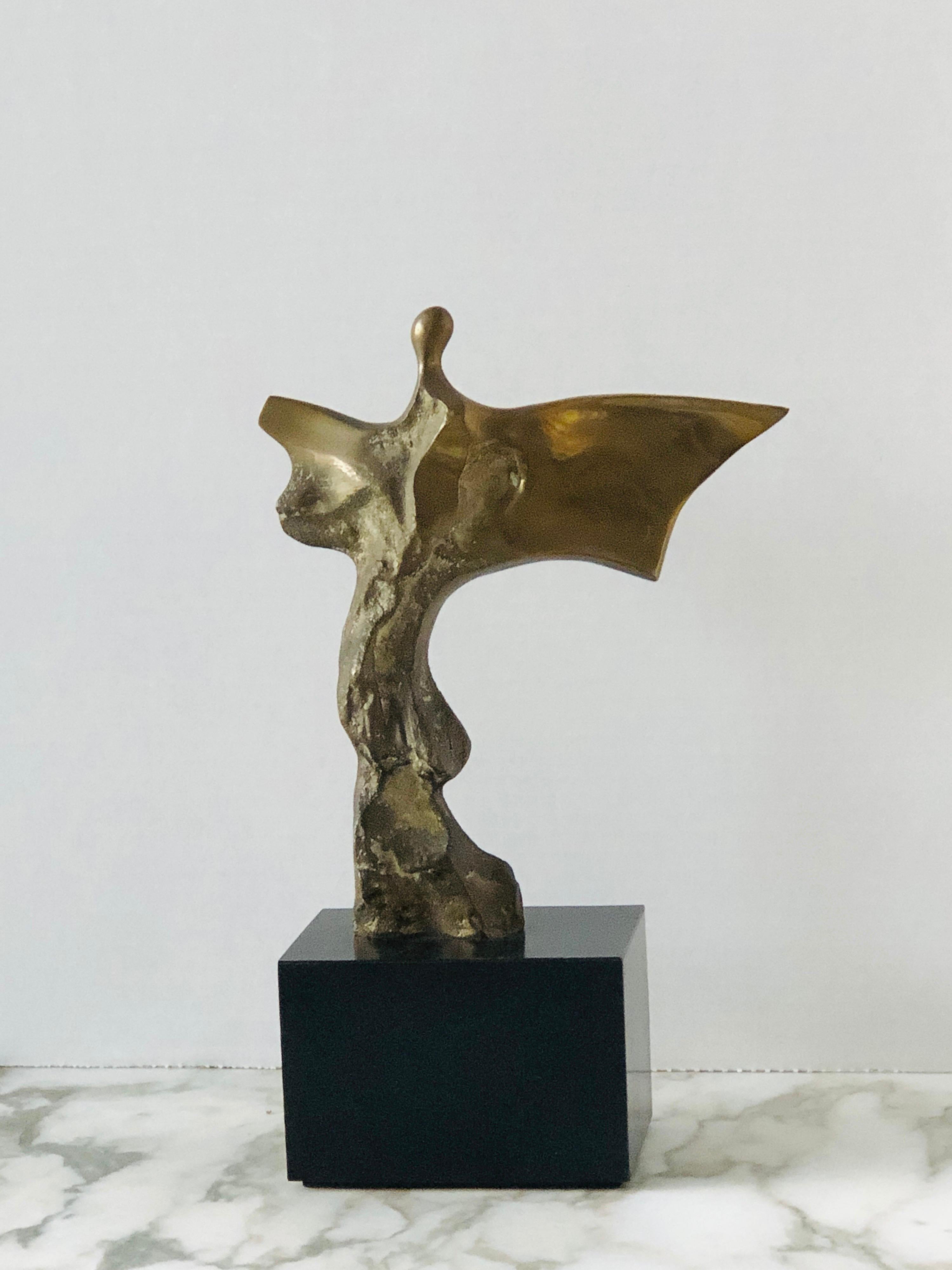 A bronze sculpture of an abstract figure in movement. Signed and numbered. On a black wood base, figure without the base measures 7.75” tall, and 6.5” wide.