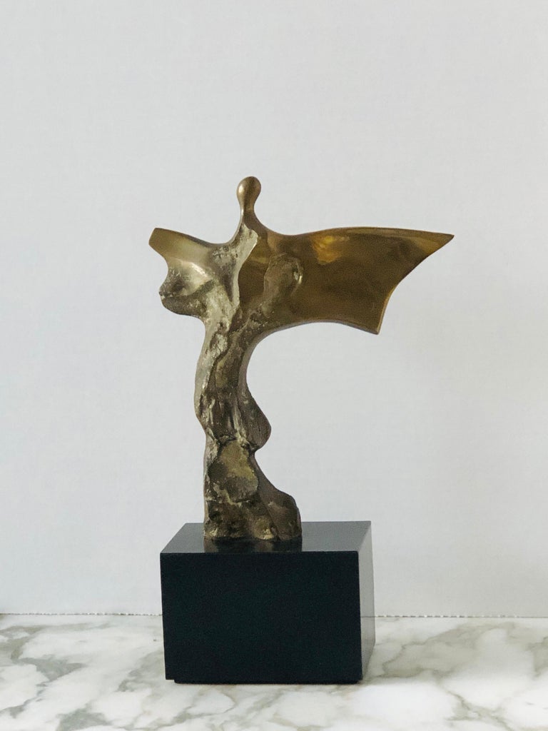 A bronze sculpture of an abstract figure in movement. Signed and numbered. On a black wood base, figure without the base measures 7.75” tall, and 6.5” wide.