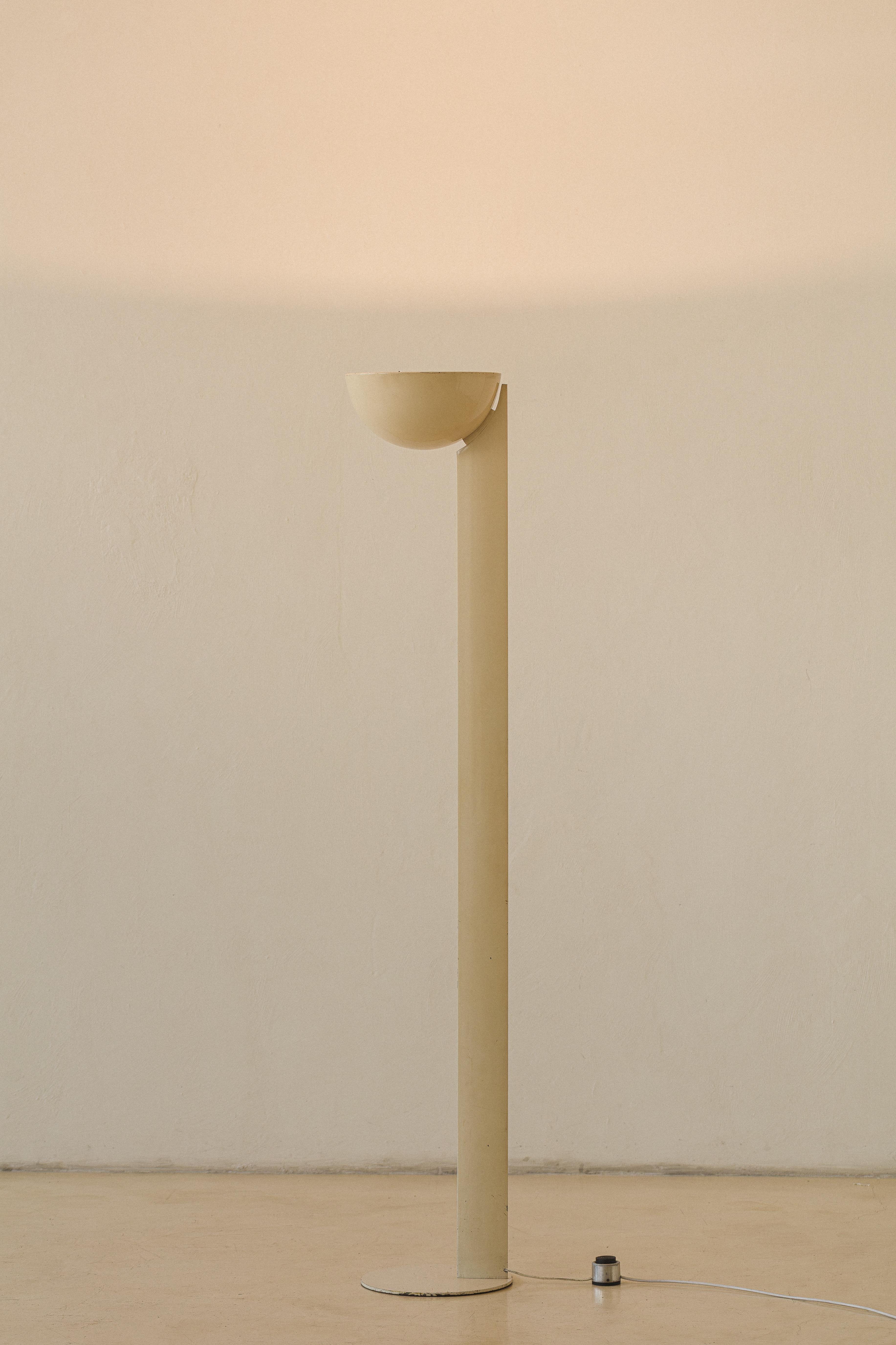 This floor lamp was designed by Enrico Furio (1909 – 2010) in the 1950s and produced by his company Dominici. Made of aluminum, the lamp is preserved in its original condition and features a singular tower and dome that throws light upwards. With