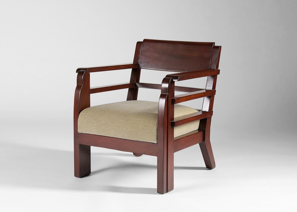 Un'elegante coppia di poltrone Deco con una forma unica in mogano, caratterizzata da fianchi e schienale a fasce, un insieme di gambe posteriori e braccioli sbarazzini che si riversano in maestosi sostegni anteriori. Stampato sotto la traversa.