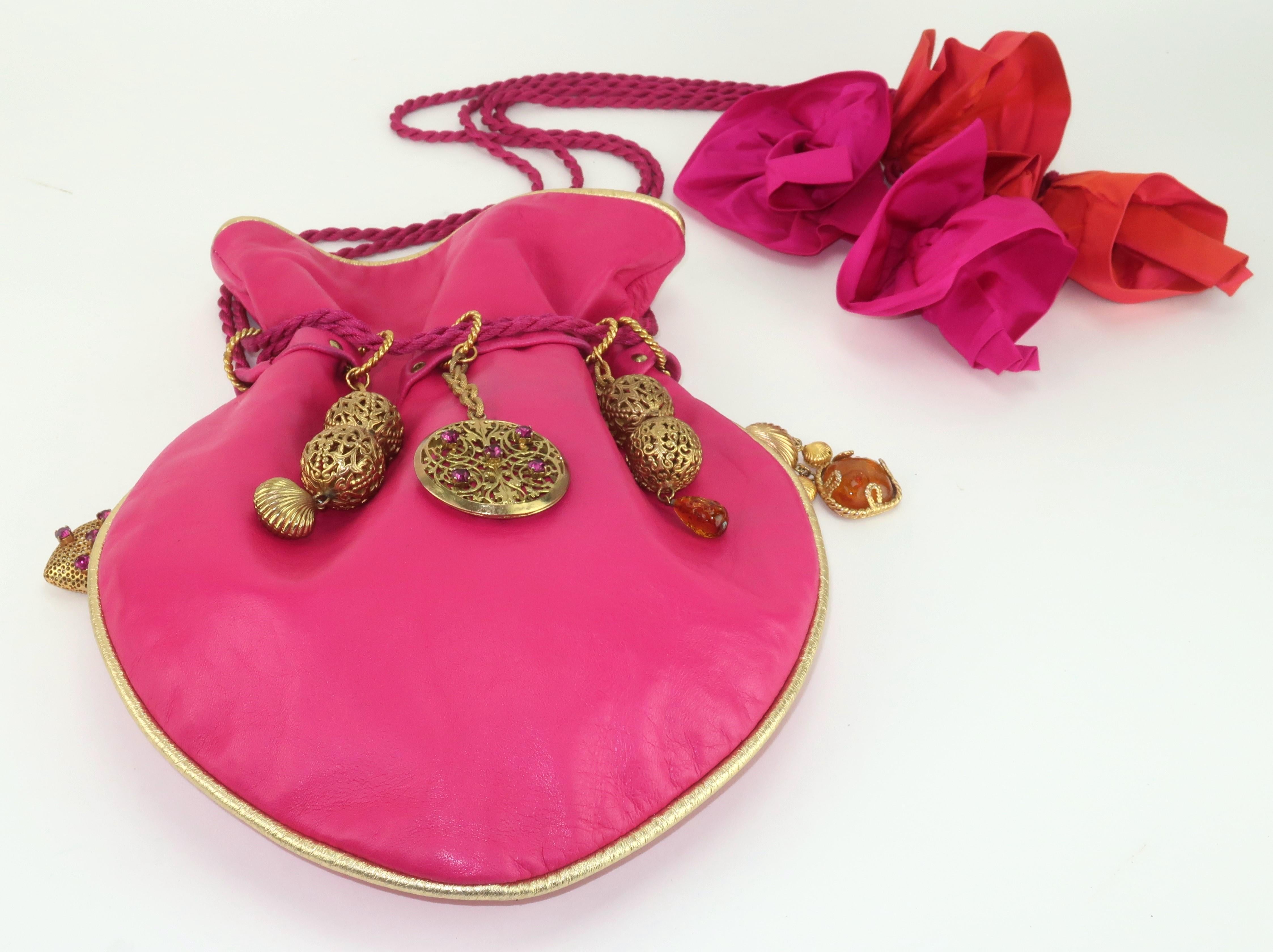 Late 1980's drawstring leather handbag by French jewelry designer, Dominique Aurientis, embellished with gold plated charms and medallions.  This fabulous handbag is a testament to 1980's maximalist style with a combination of a functional