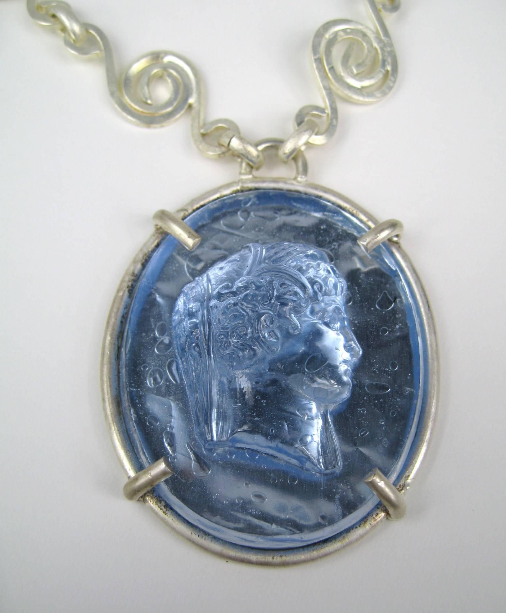 Stunning ocean blue Intaglio Set in silver Tone.  Large circular motif chain with a Toggle closure. Measuring 29.5 in end to end. 1.86 in x 2.46 in top to bottom. This French jewelry designer has a vast international customer base and is known
