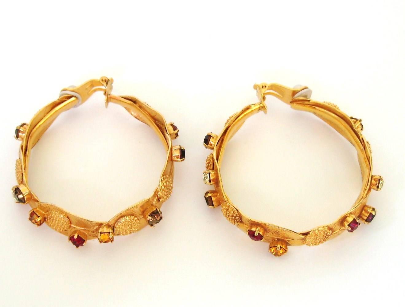 These are Fabulous Hoop earrings, from a collection of Dominique Aurientis. Oversized gilt metal hoops with prong set colored crystals set all around the entire hoop. Clip On style earrings. 2.19 inches. We have many more pieces on our storefront.