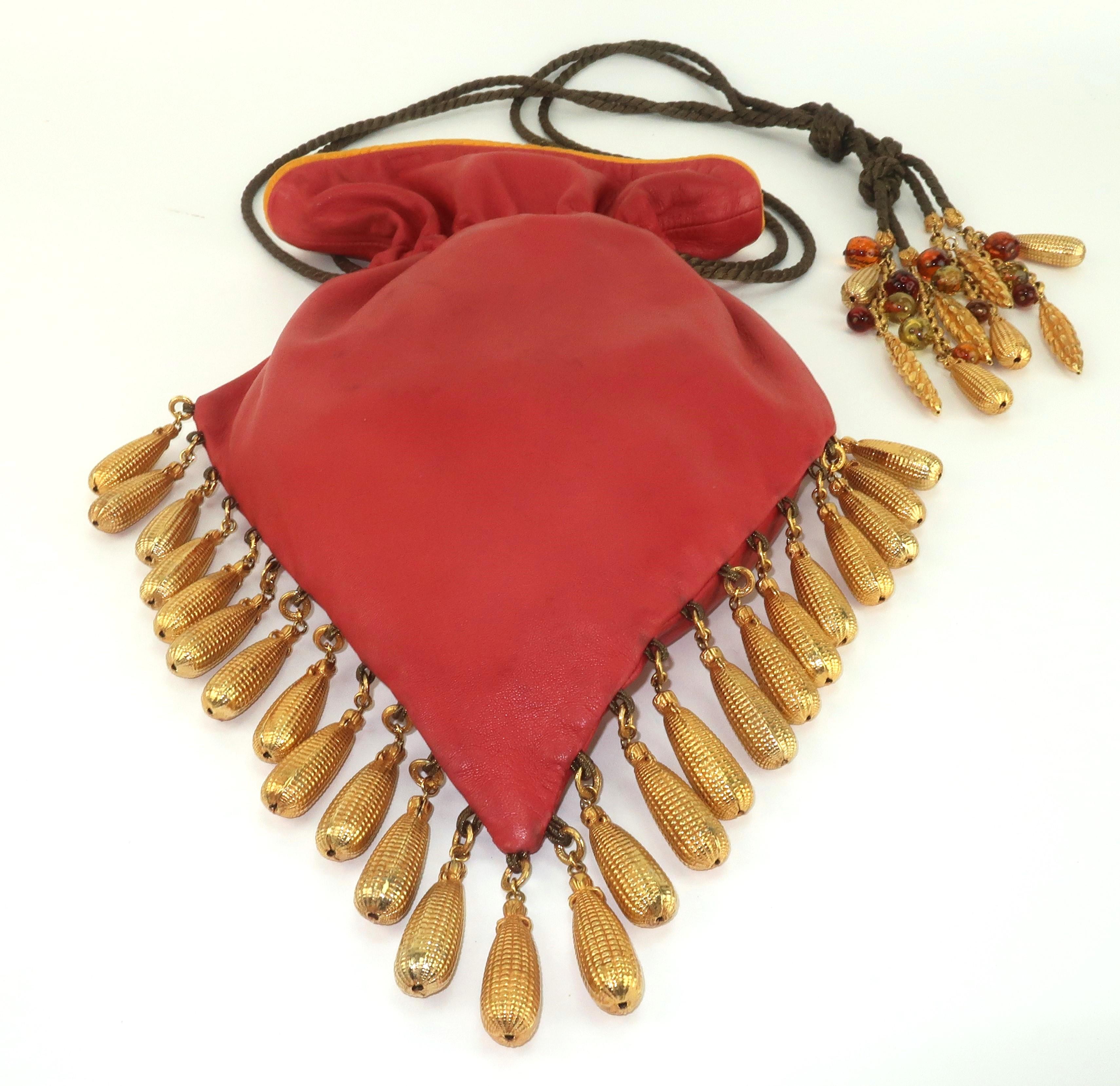 Late 1980's drawstring leather handbag by French jewelry designer, Dominique Aurientis, embellished with gold plated charms and glass beads.  This fabulous handbag is a testament to 1980's maximalist style with a combination of a functional