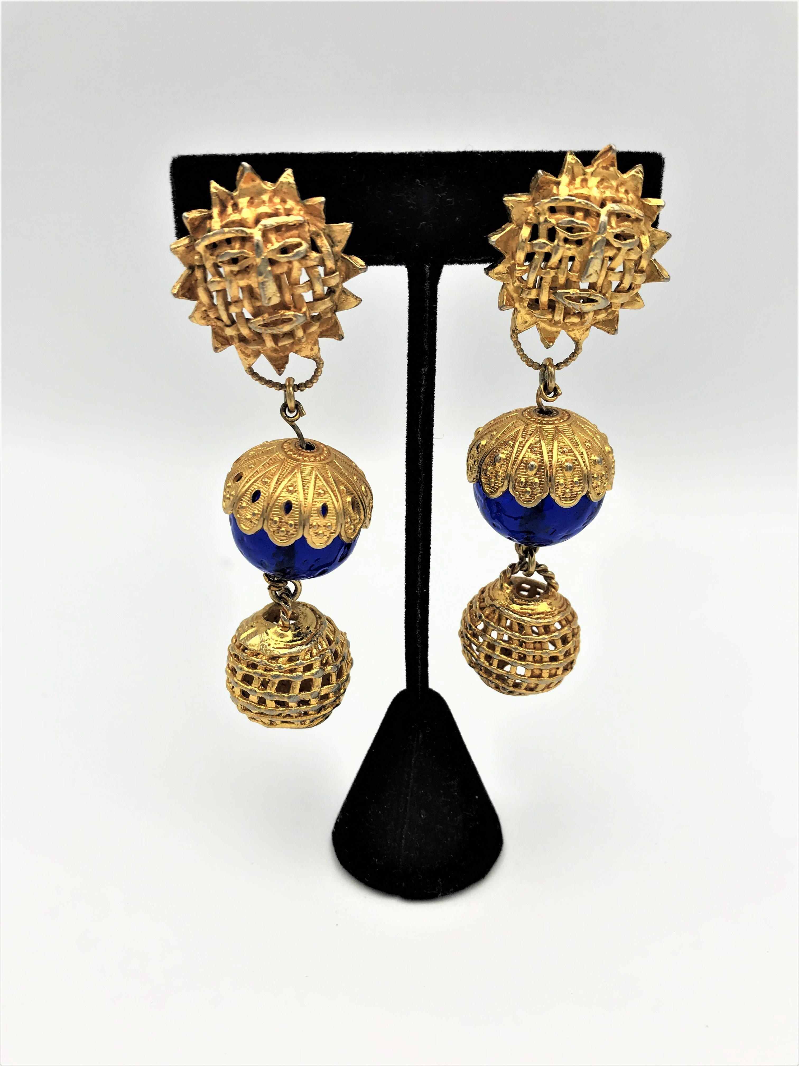 Clip-on earrings from Dominique Aurientis Paris. Consists of 3 balls. 
1. Ball sun with face/sun god,2. blue Gripoix ball with gold hood, last openwork ball. 
Measurement: Length 8 cm/3, Sun ball 2,4 cm/1