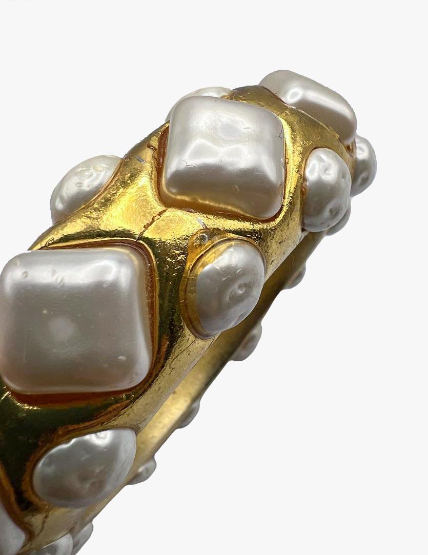 Dominique Aurientis Paris goldfarbenes Armband mit Kunstperlen im Barockstil

Das Armband ist aus geformtem Harz in goldener Farbe gefärbt und mit Glas-Cabochons verziert, die barocke Perlen imitieren. 

Markiert auf der Innenseite des