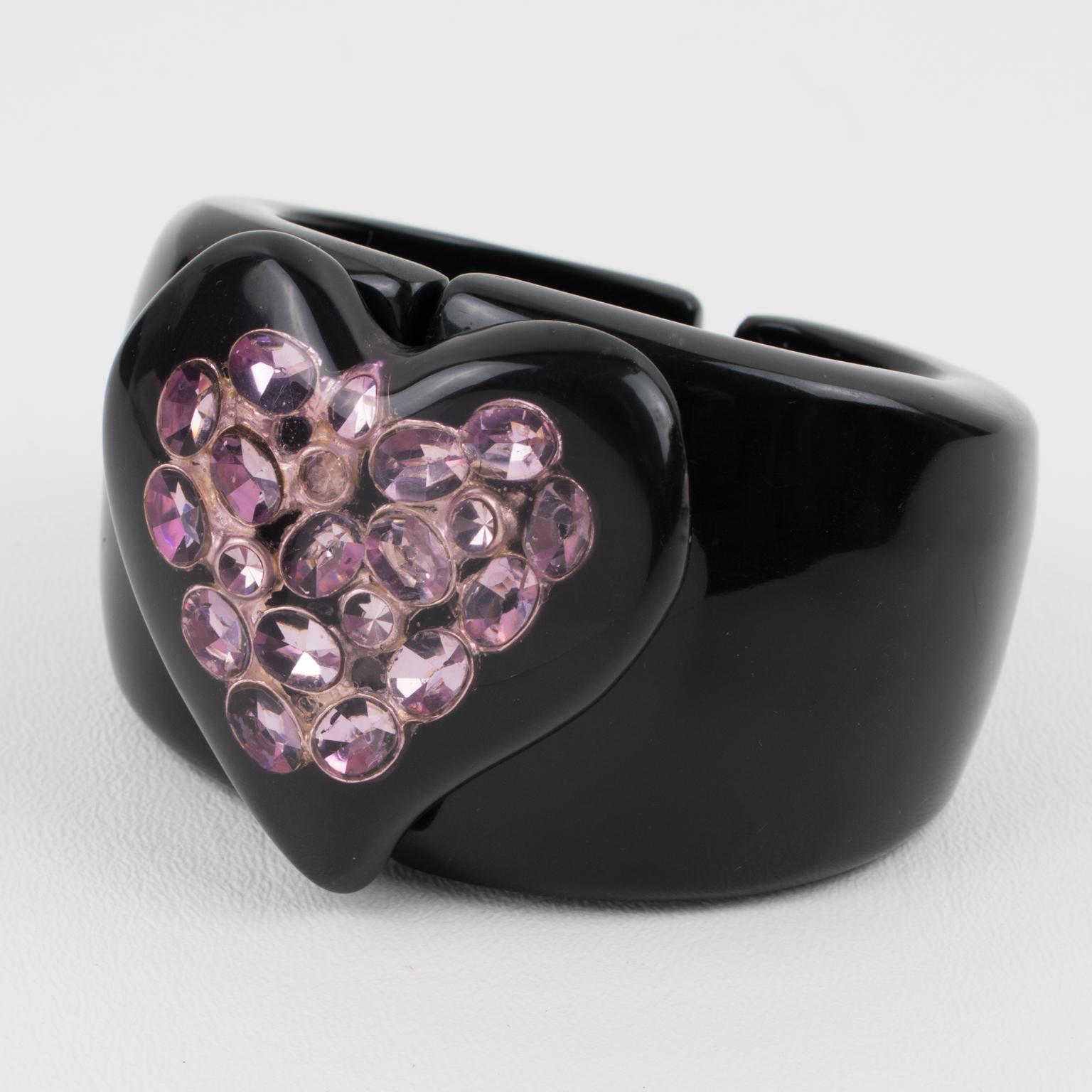This gorgeous French designer Dominique Denaive, Paris oversized bracelet features a licorice black resin clamper shape with a large heart-shaped cabochon. The heart cabochon has lavender-purple crystal rhinestones embedded in the material. The