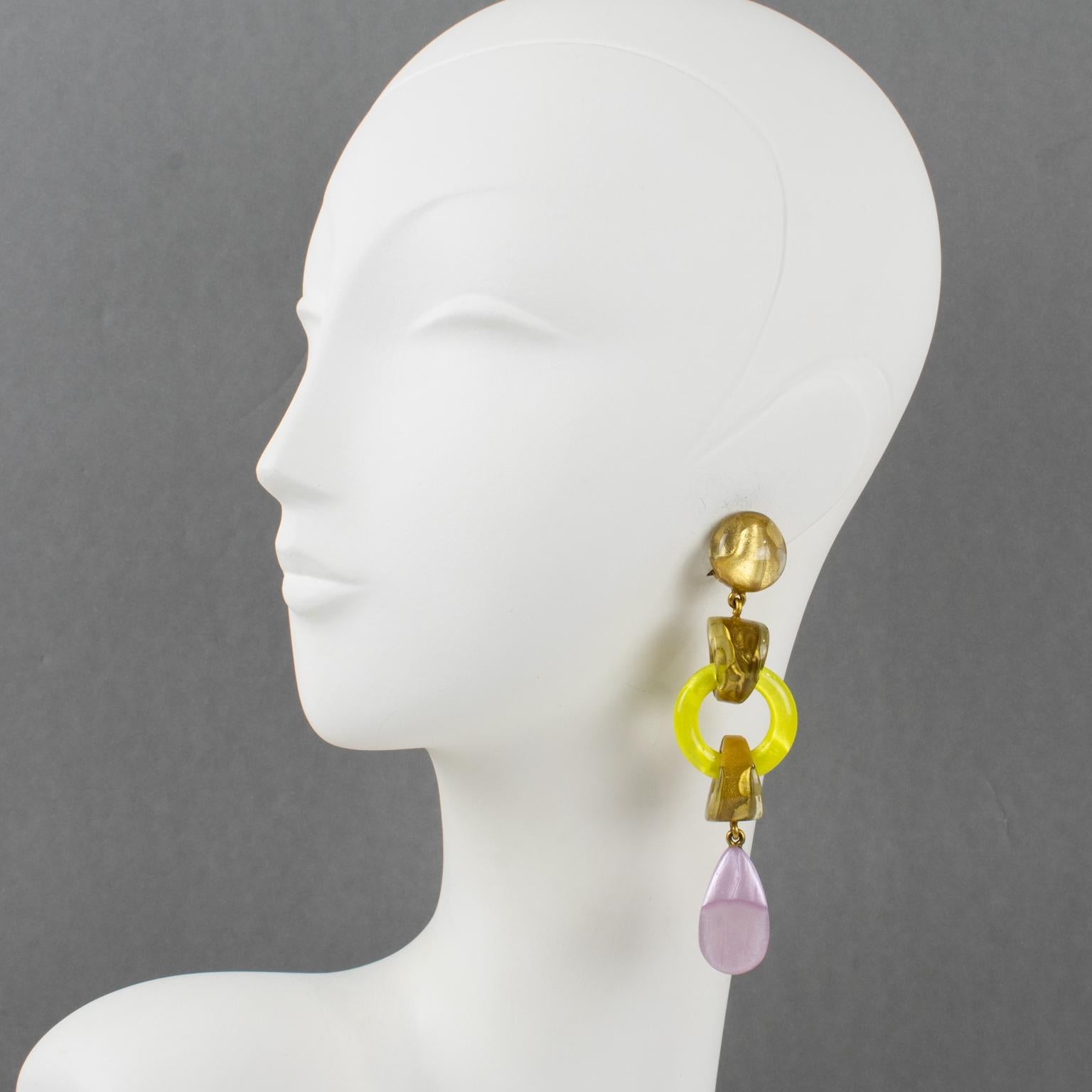 Dominique Denaive, Paris, designed these spectacular clip-on earrings. They feature a dangling shape in resin with drops and donuts in lovely citrus yellow, light purple lavender, and pearlized gold colors. The engraved signature at the back of each